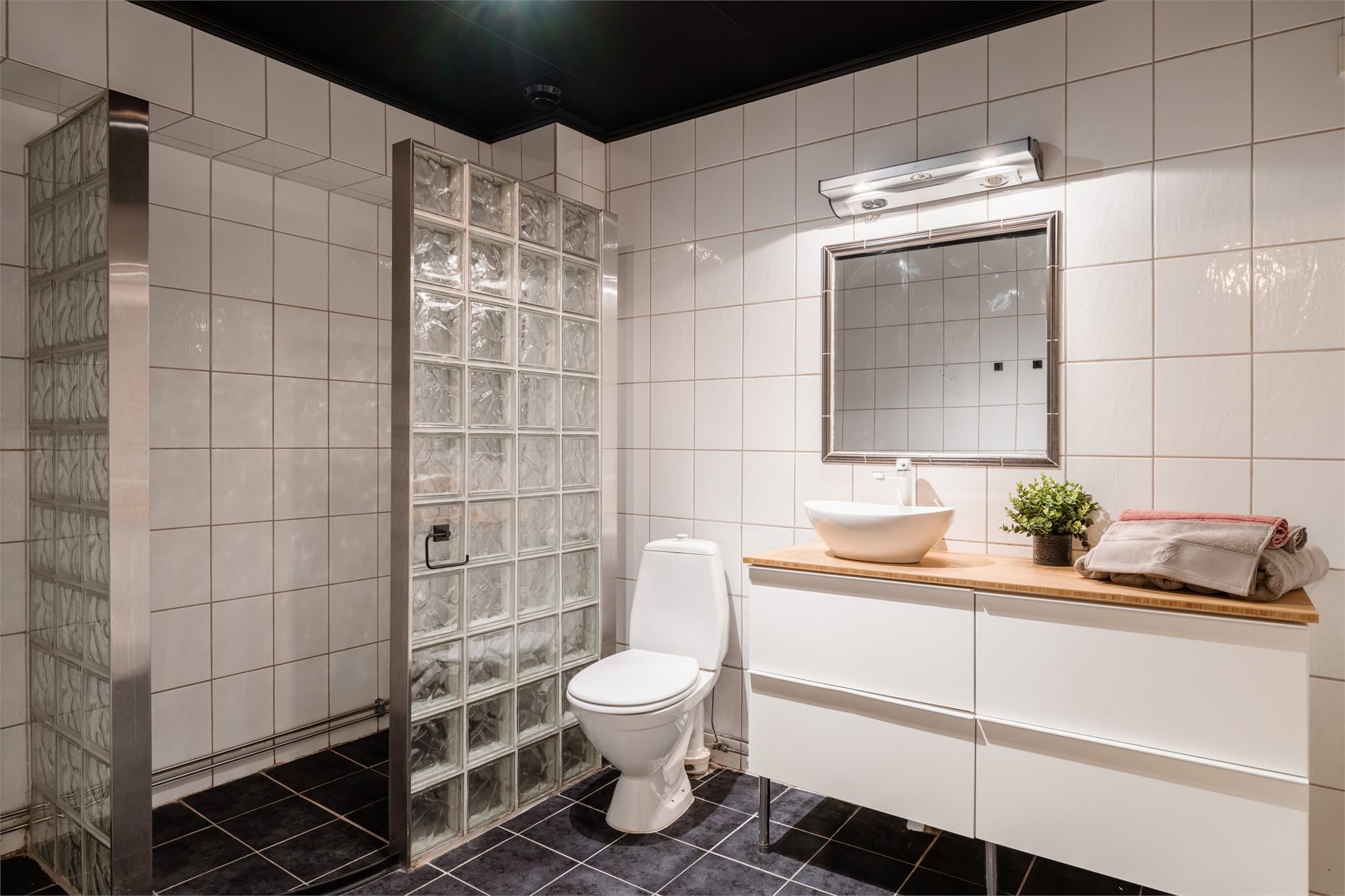 Badet i første etasje har flislagte overflater og varmekabler i gulvet.