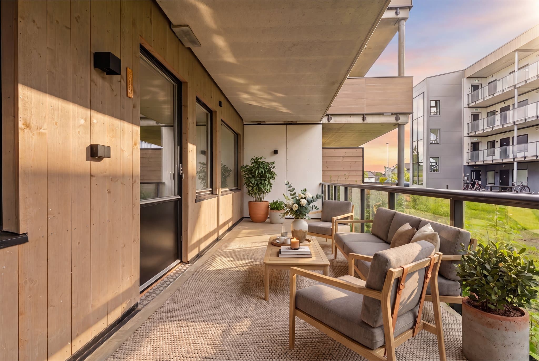 Stor terrasse vendt mot syd og sameiets hyggelige fellesområde. Foto: Thor Øyvind Borgersen, FlytendeFilm. Bildet er digitalt møblert - avvik kan forekomme.