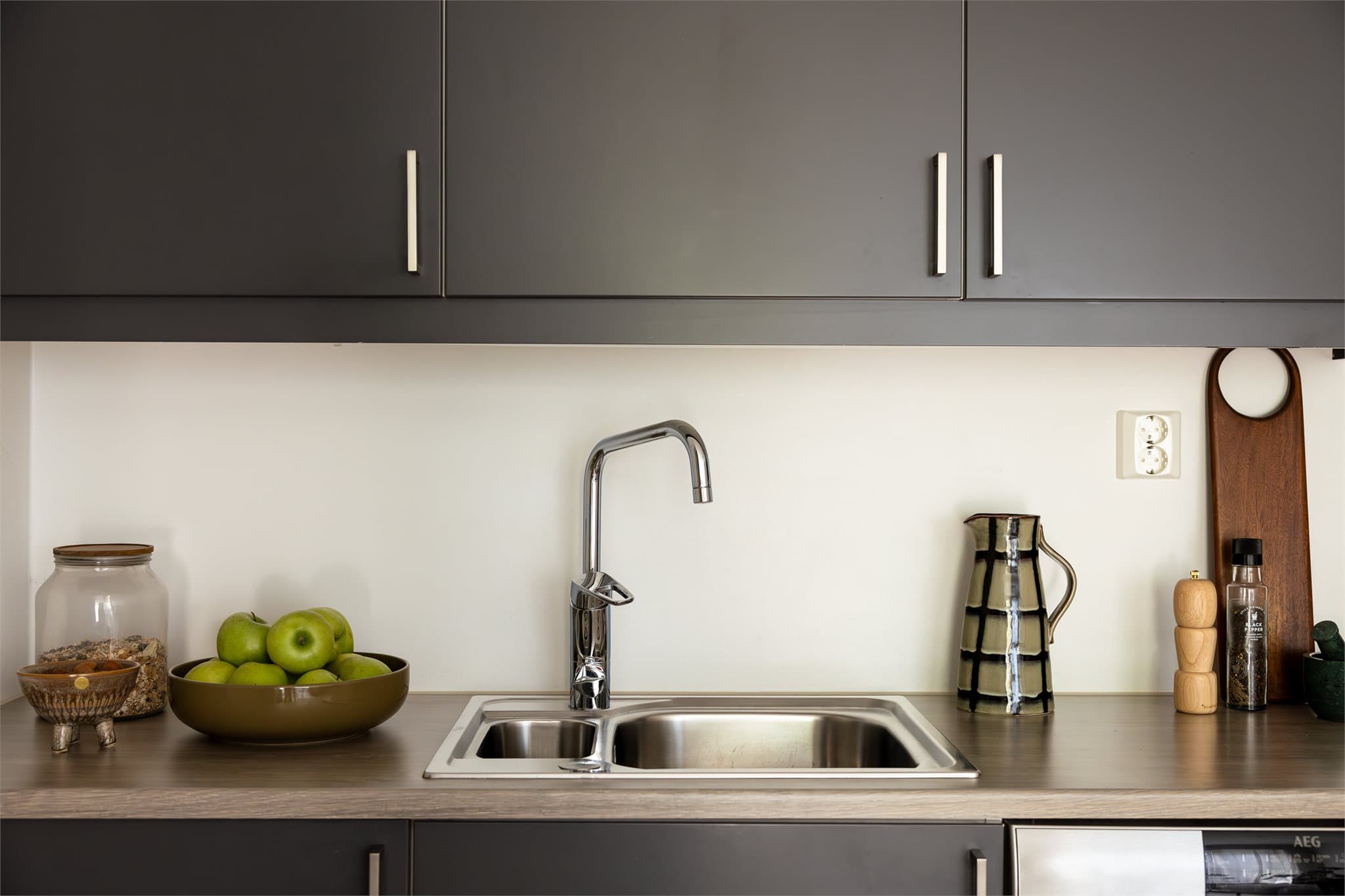 Laminat benkeplate med oppvaskkum og ett greps svingbart blandebatteri. Induksjon koketopp og innebygget stekeovn. Nisje til kjøleskap/fryser og oppvaskmaskin.