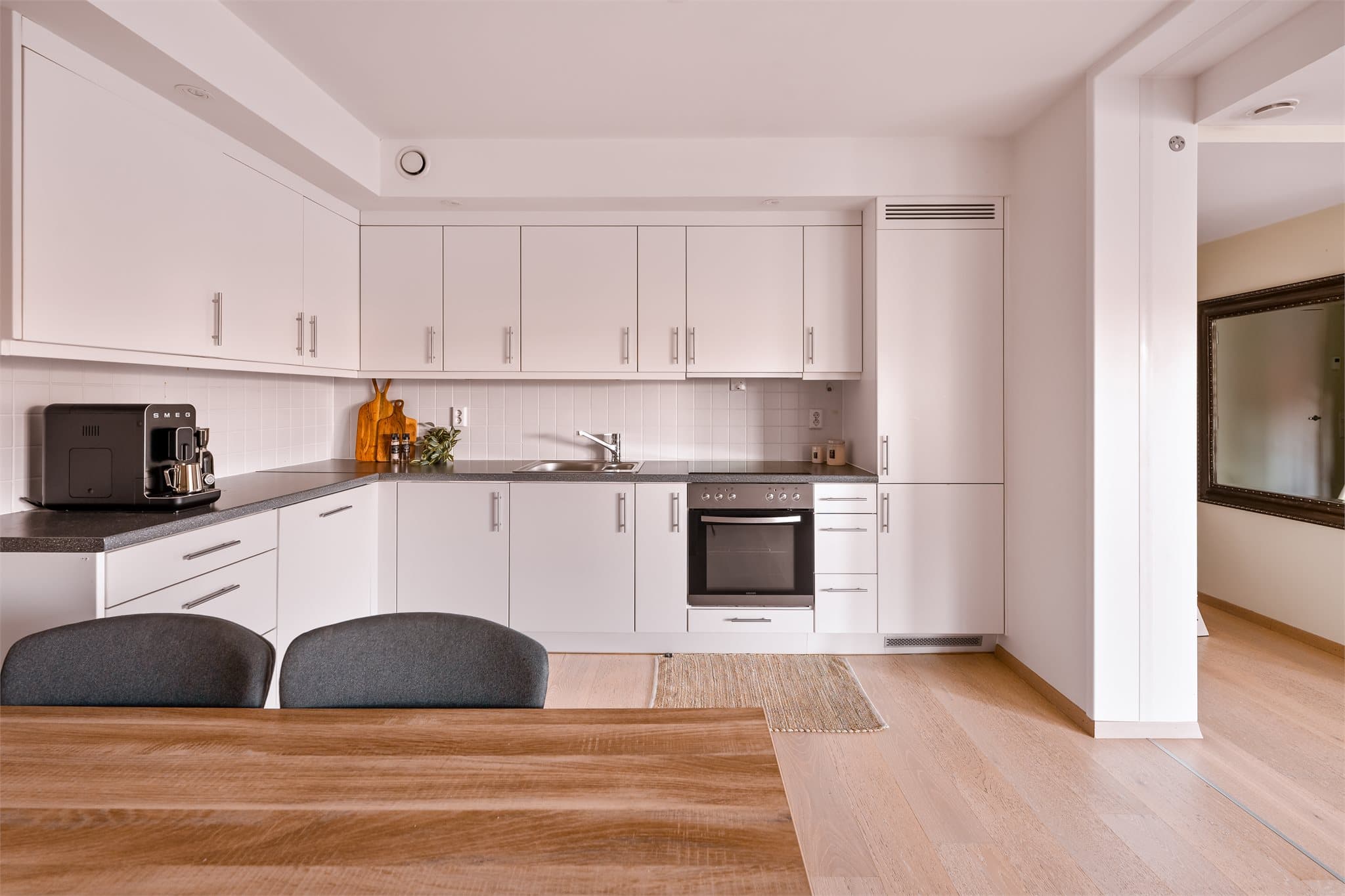 Lyst og pent kjøkken med integrerte hvitevarer. Det er godt med skap- og benkeplass.