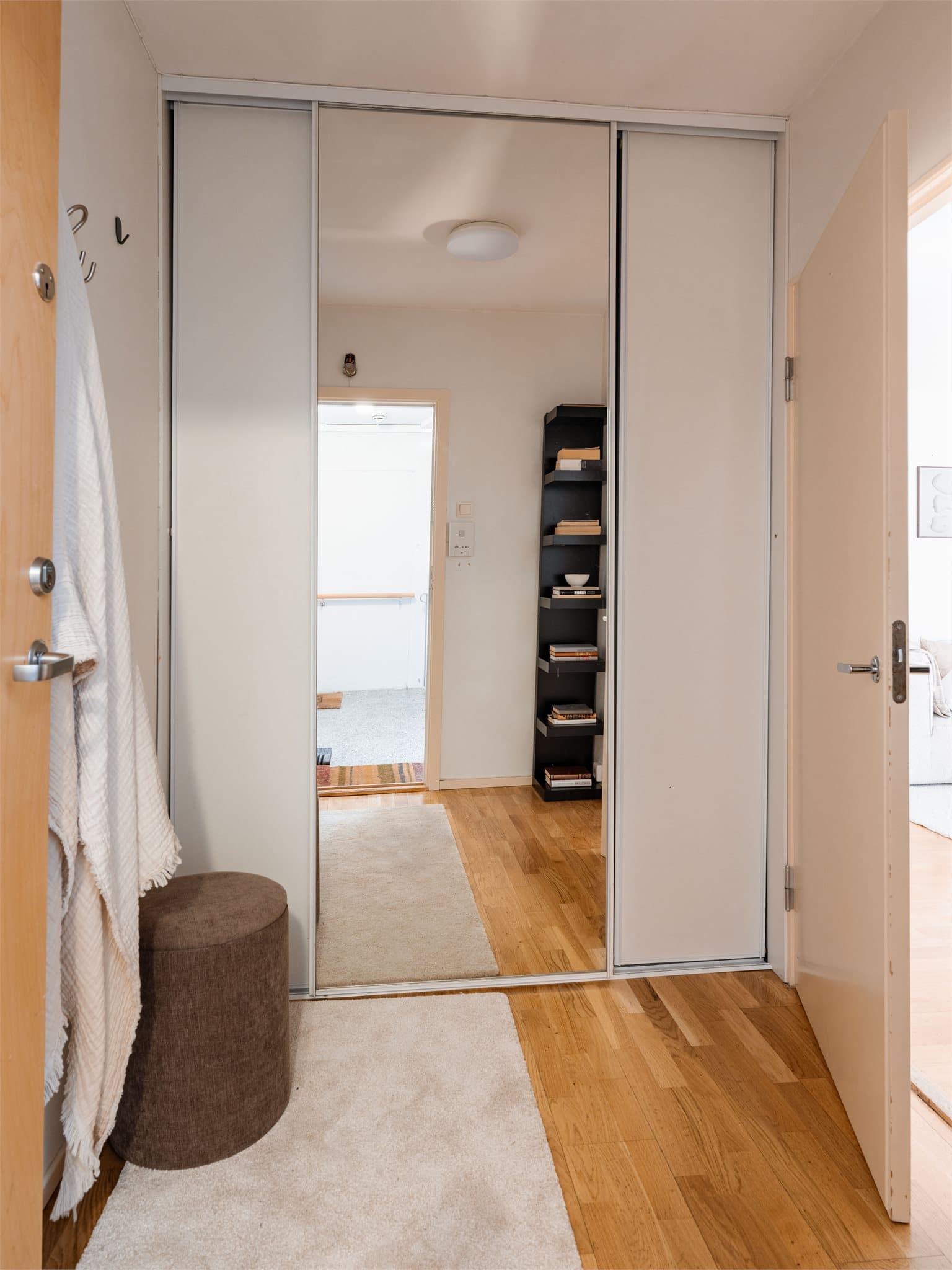 En romslig skyvedørsgarderobe med speilfronter sørger for god oppbevaring i entreen.