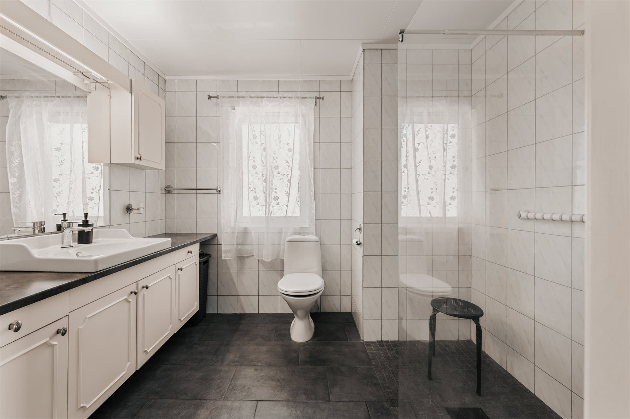 Pent, flislagt bad med gulvvarme fra 2022. Badet er innredet med servantinnredning, gulvmontert toalett og dusjløsning.