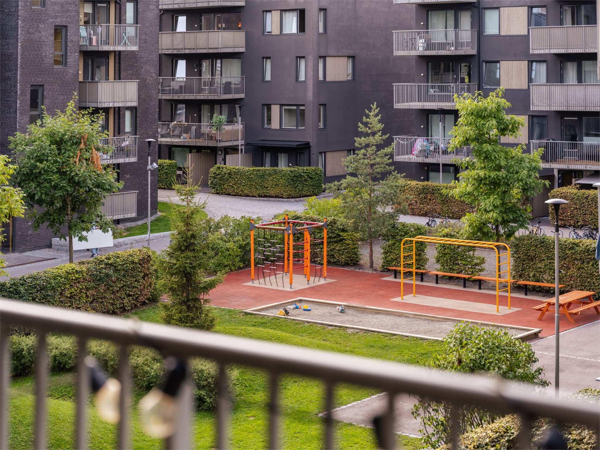 Fra balkongen er det utsikt mot et pent opparbeidet gårdsrom med boltreplass for både store og små.