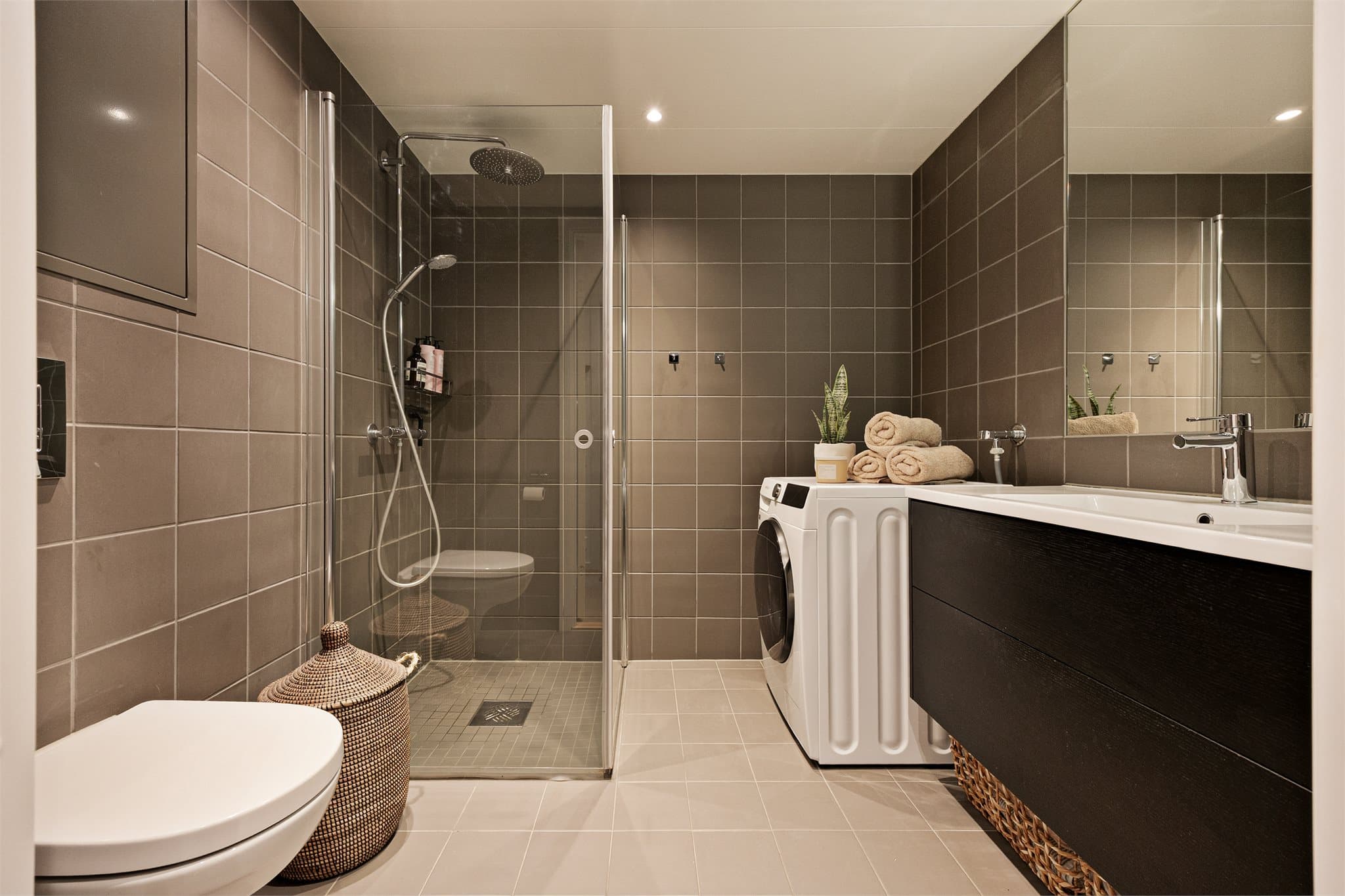 Lekkert og tidløst baderom med flislagte overflater. Badet har gulvvarme.