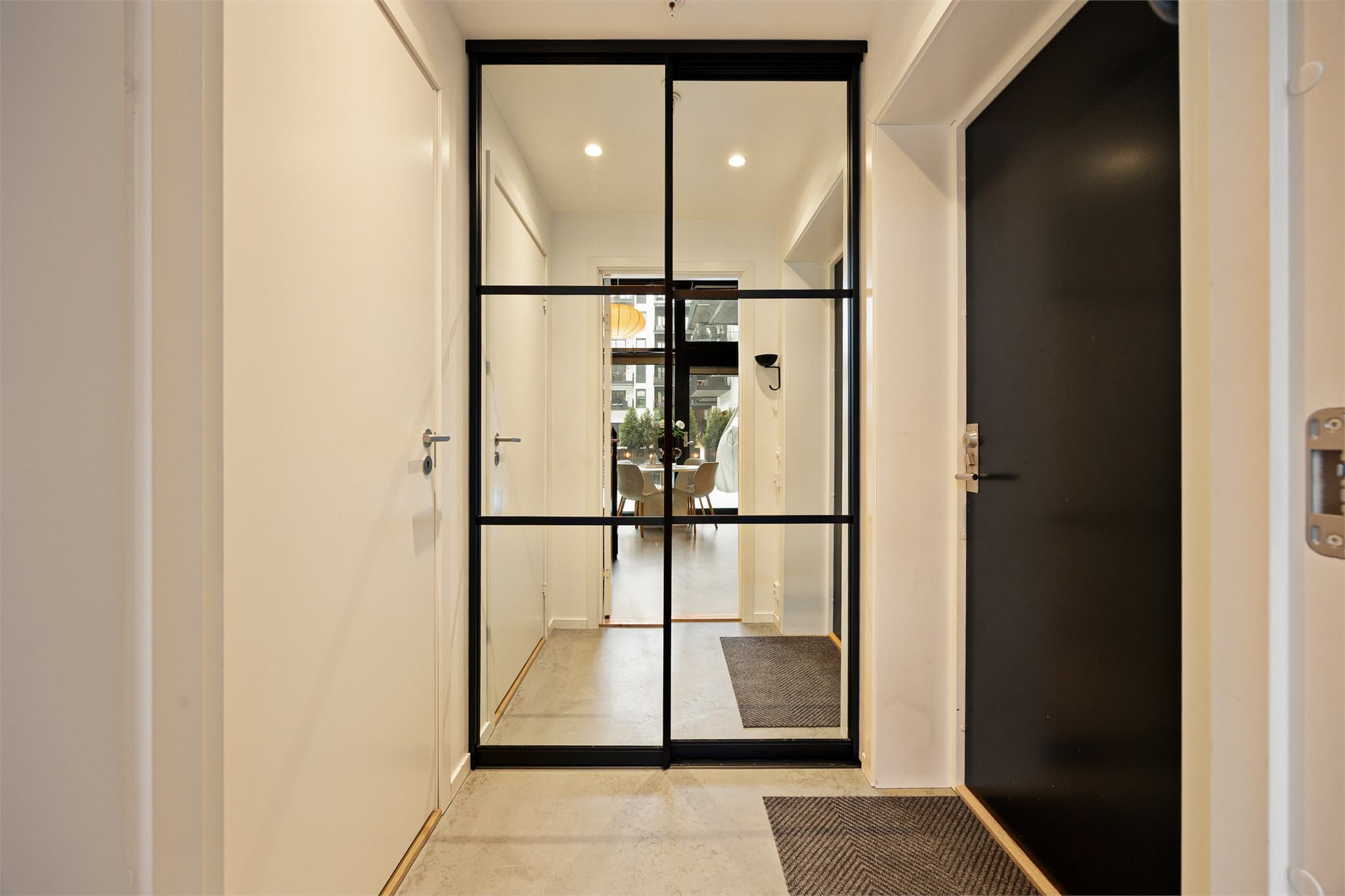 Velkommen inn! Lysmalt entré med skyvedørsgarderober og downlights i himling.