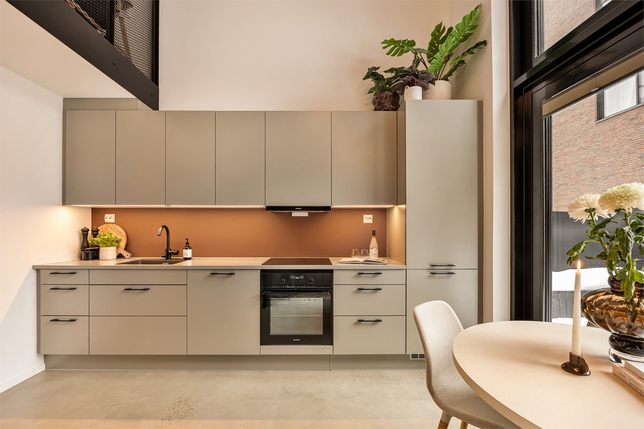 Kjøkkeninnredningen har slette fronter og laminat benkeplate med nedfelt kjøkkenkum.