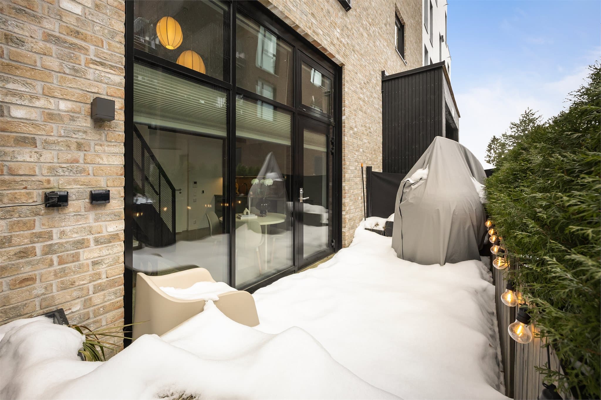 Det er montert levegger og hekk i blomsterkasser. Terrassen har utebelysning og stikkontakter