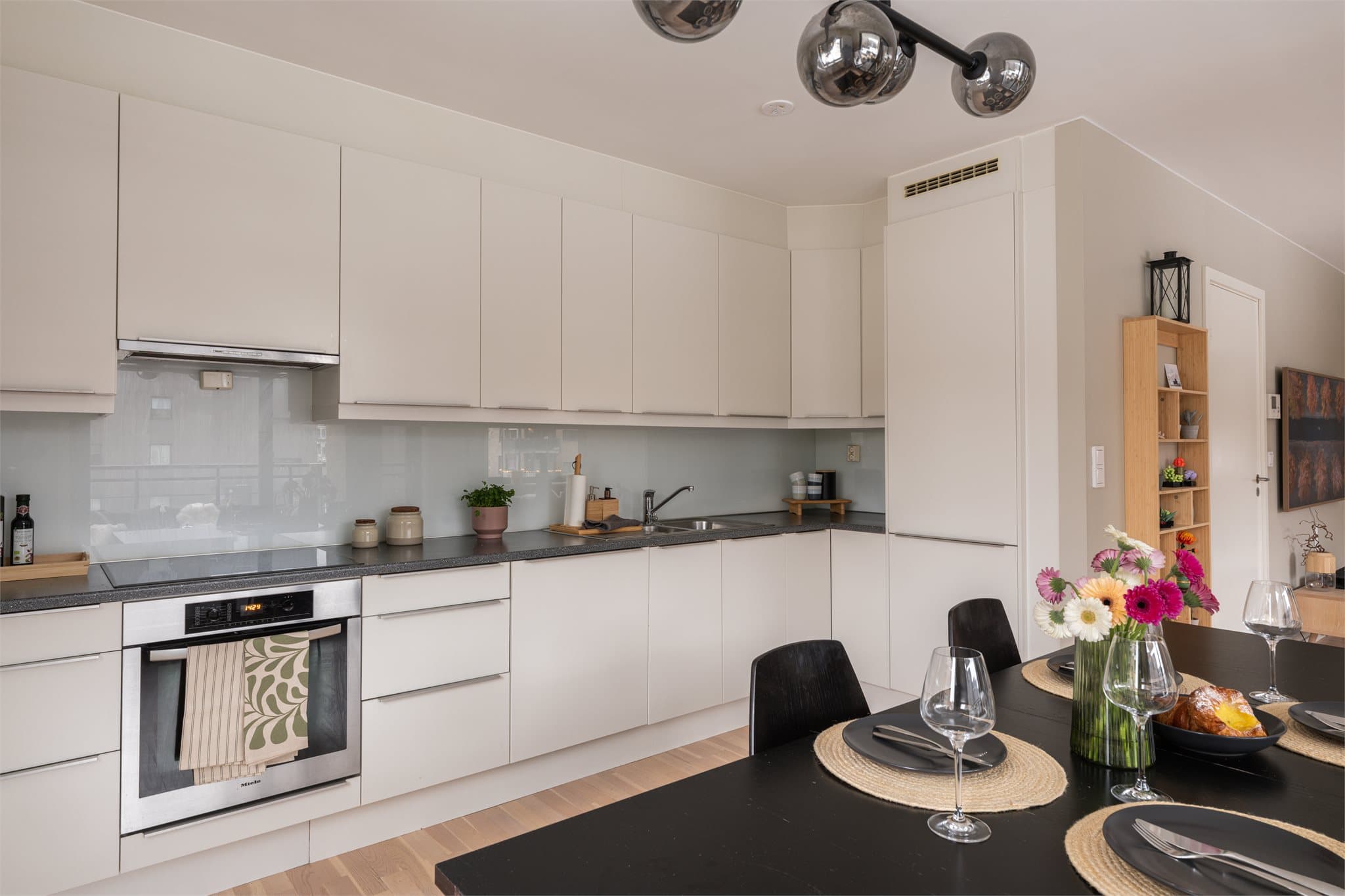 Lyst og tidløst kjøkken med god oppbevaringsplass i skuffer og skap.