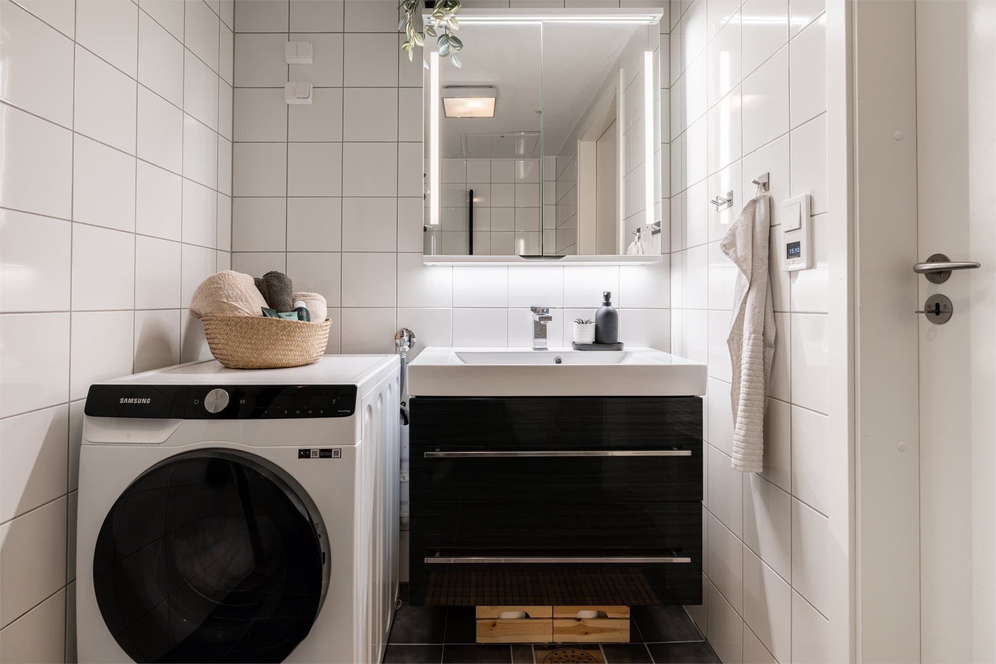 Speilskap med integrert lys, servant med skuffer og opplegg for vaskemaskin.