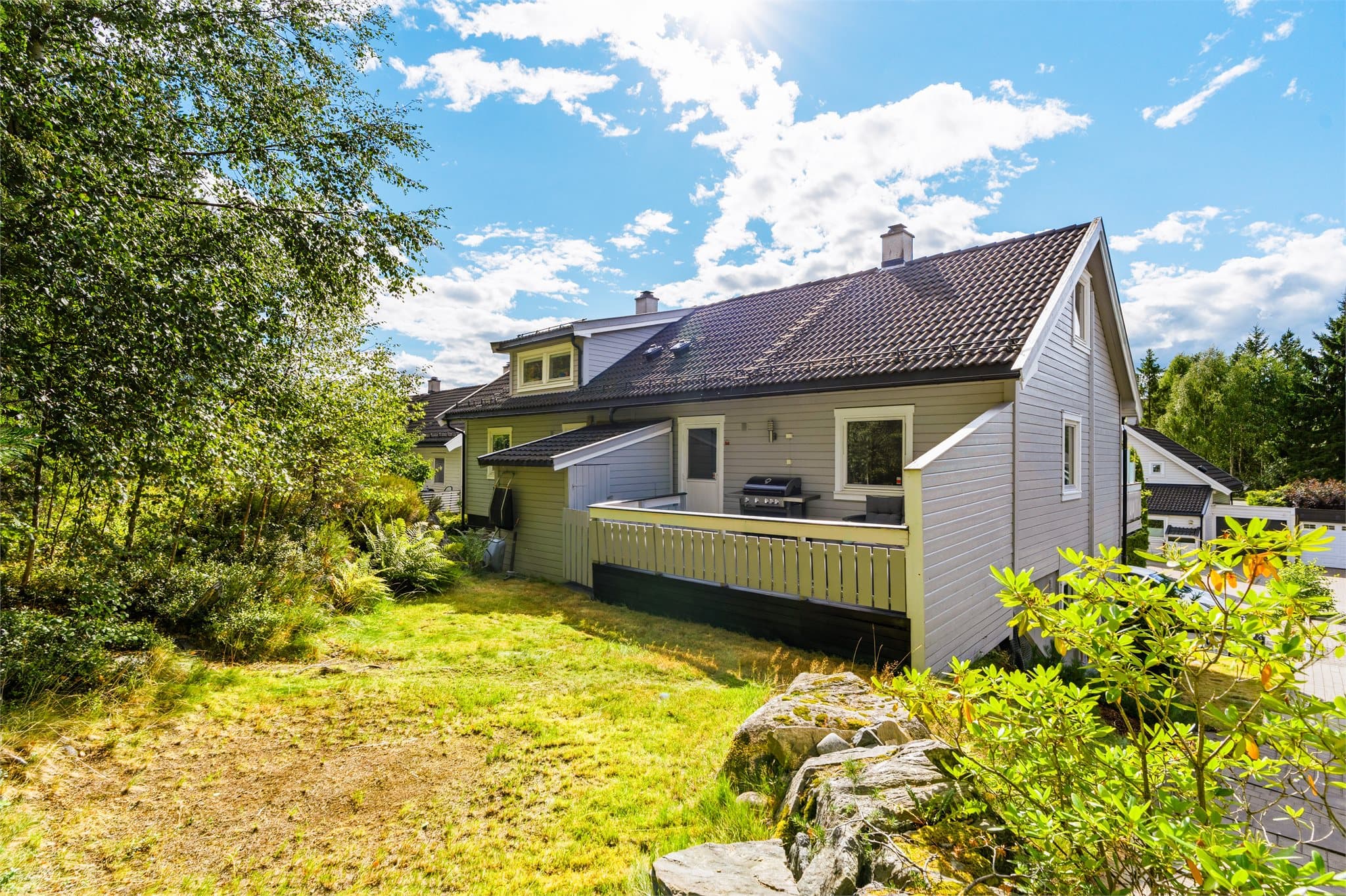 Skjermet hage og veranda på baksiden av huset. Her finner man også en utebod som gir ekstra lagringsplass.