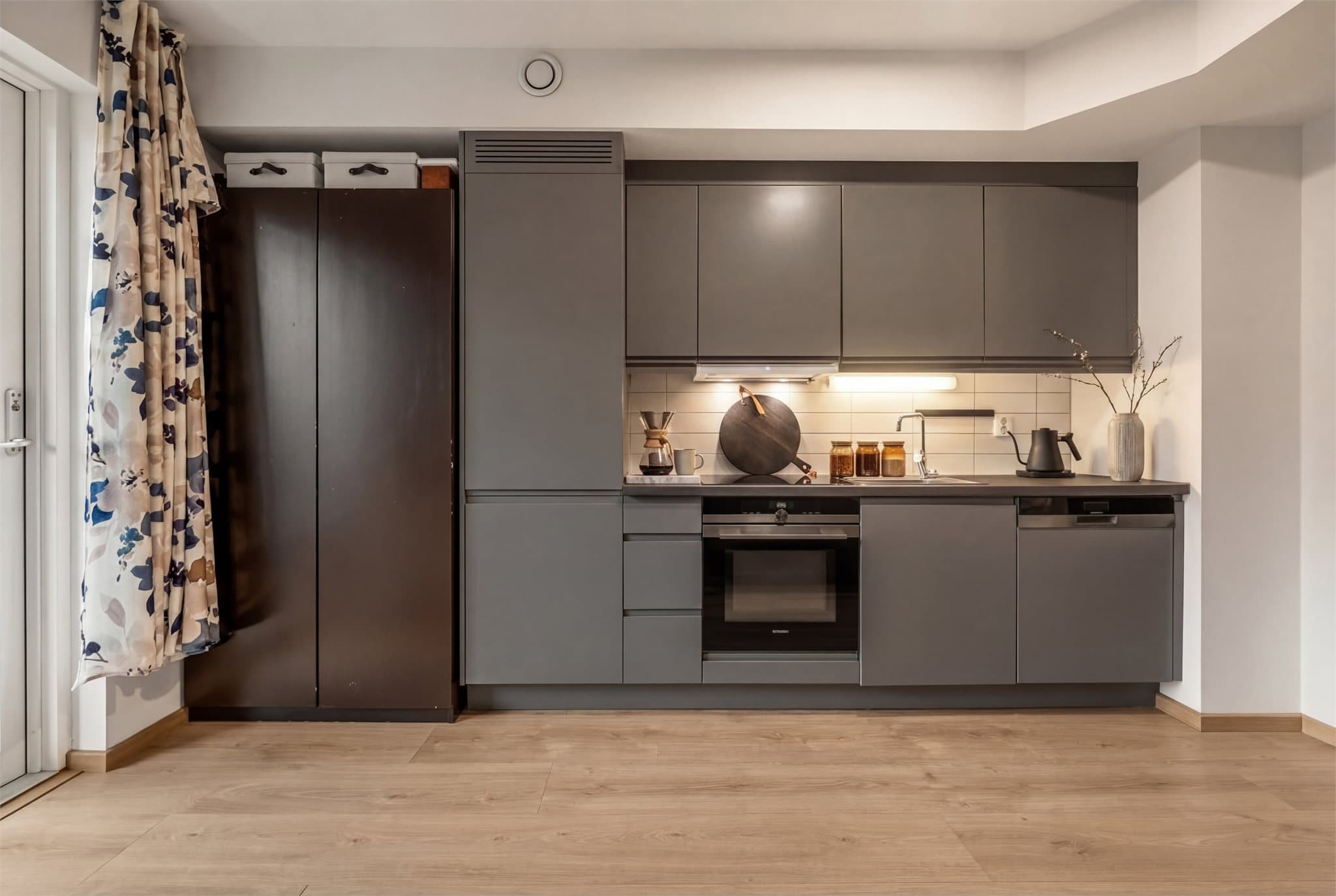 En stilren kjøkkeninnredning med integrerte hvitevarer.