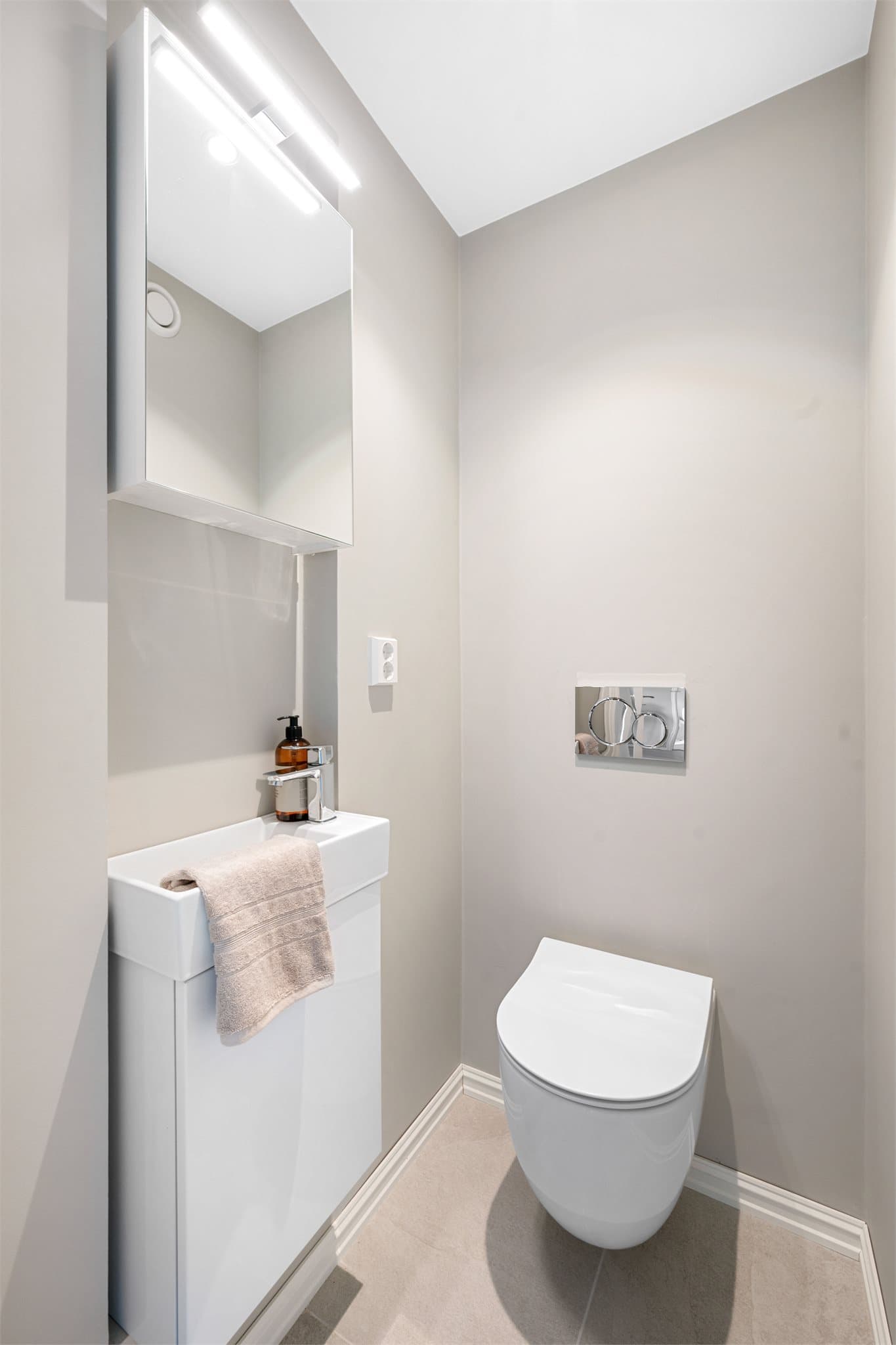Separat toalettrom med vegghengt toalett og gjennomgående moderne detaljer som gir et rent og helhetlig uttrykk.