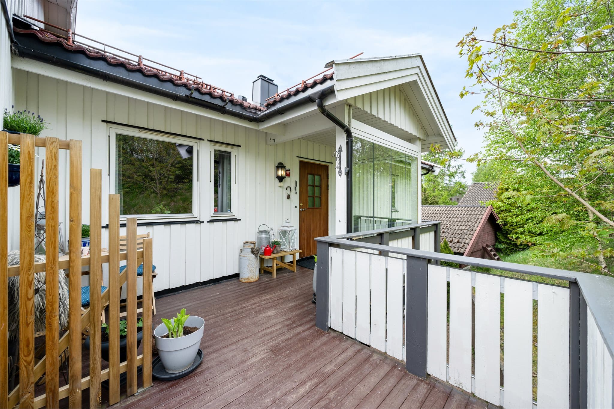 Et sjarmerende og lunt inngangsparti med plass til morgenkaffen i solen – en hyggelig velkomst til leiligheten.