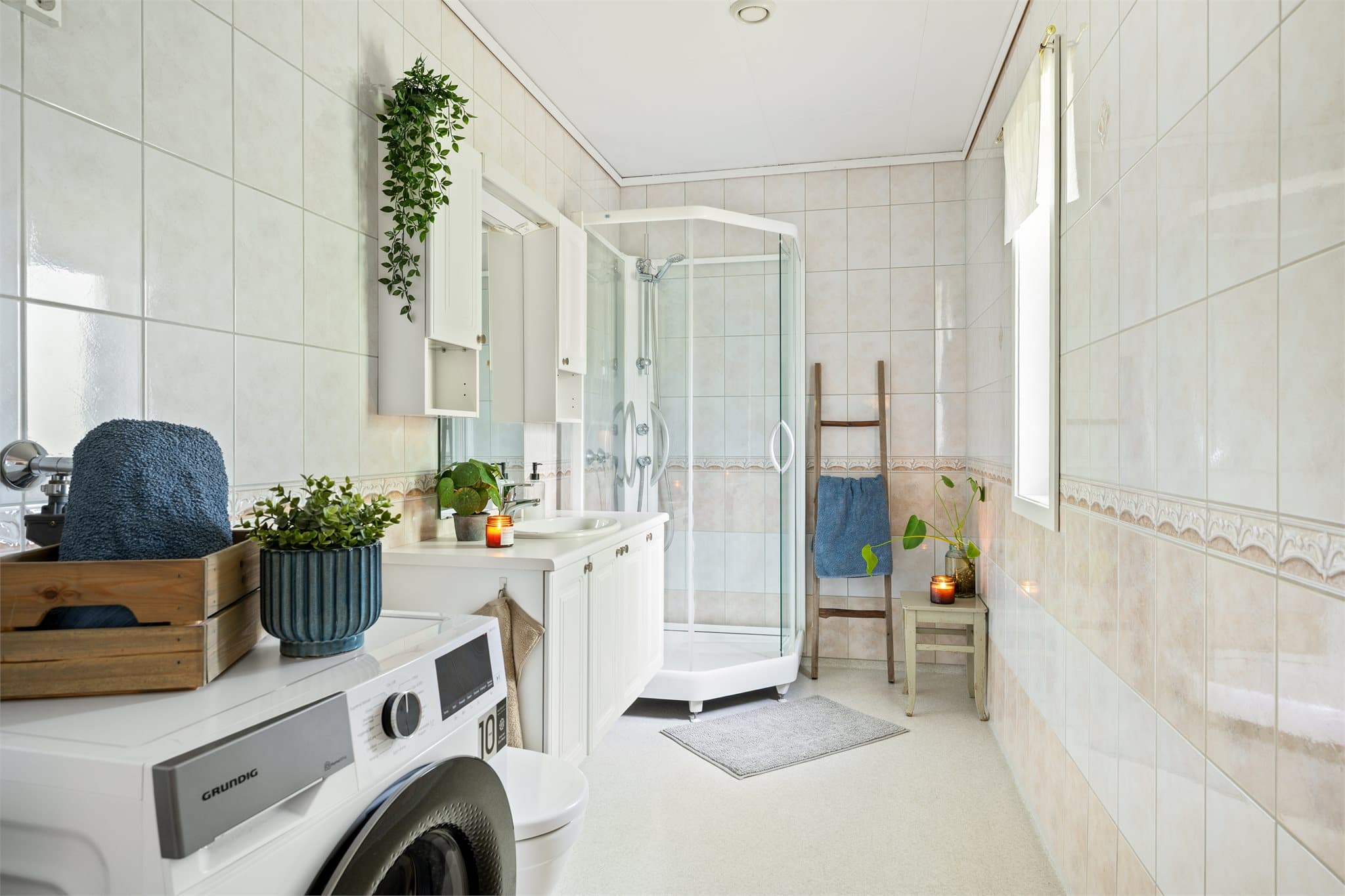 Badet er innredet med helservant på underskap, klosett og dusjkabinett. Opplegg for vaskemaskin.
