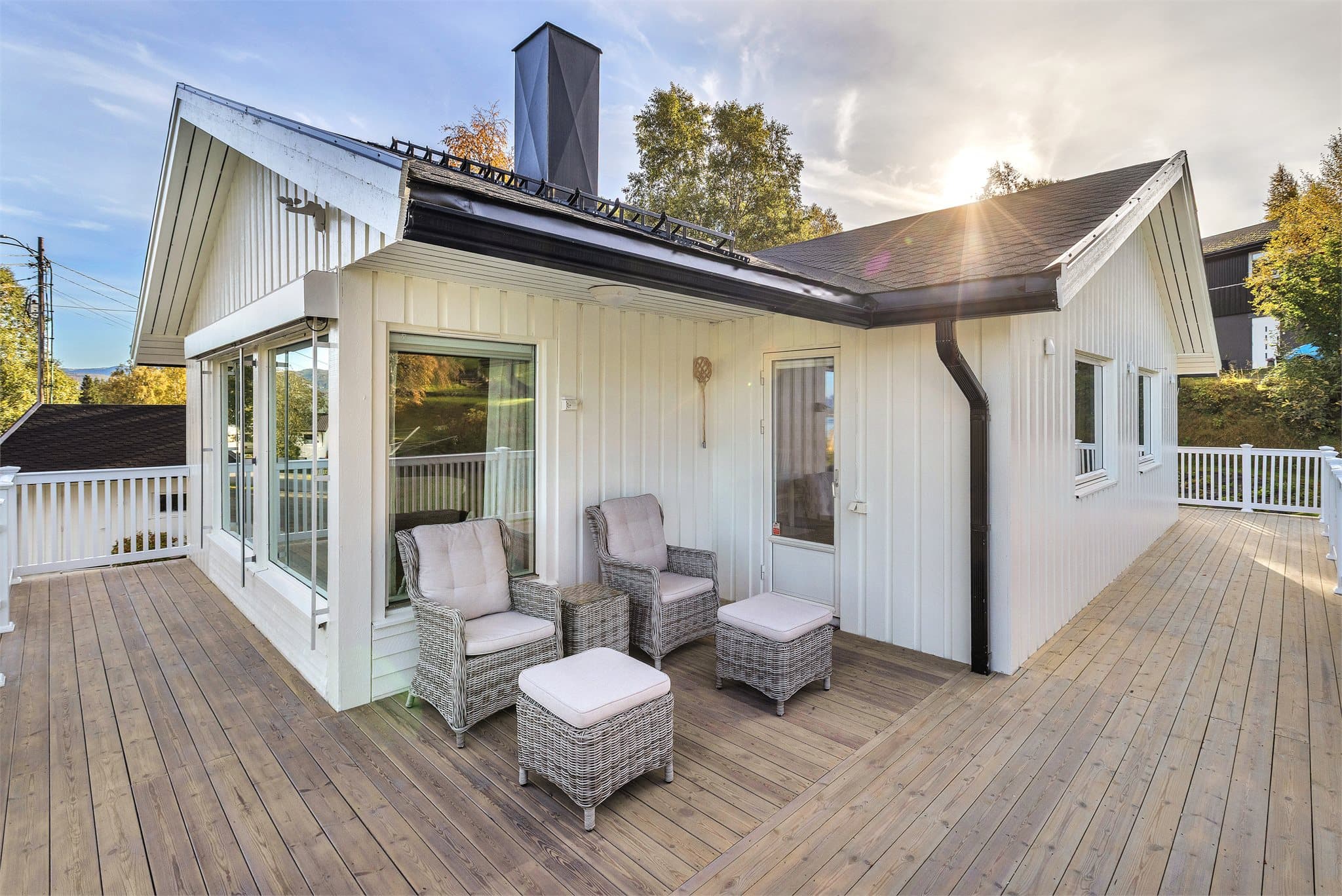 Verandaen strekker seg rundt fasaden med god plass til flere sitteplasser.