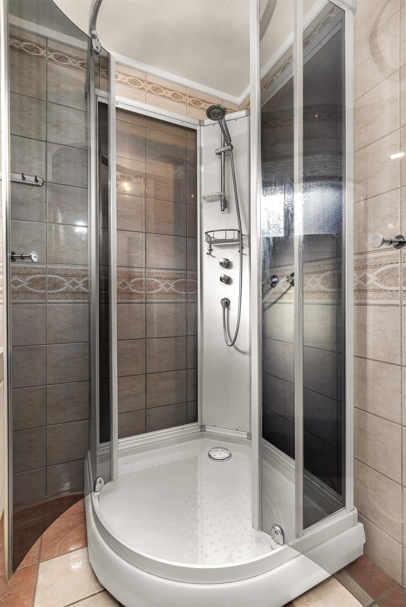 Badet er innredet med buet dusjkabinett.