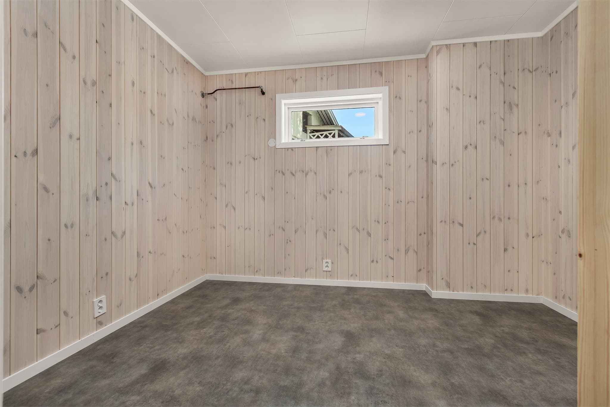 Ekstra lagringsbod med panelkledning og lite kjellervindu.