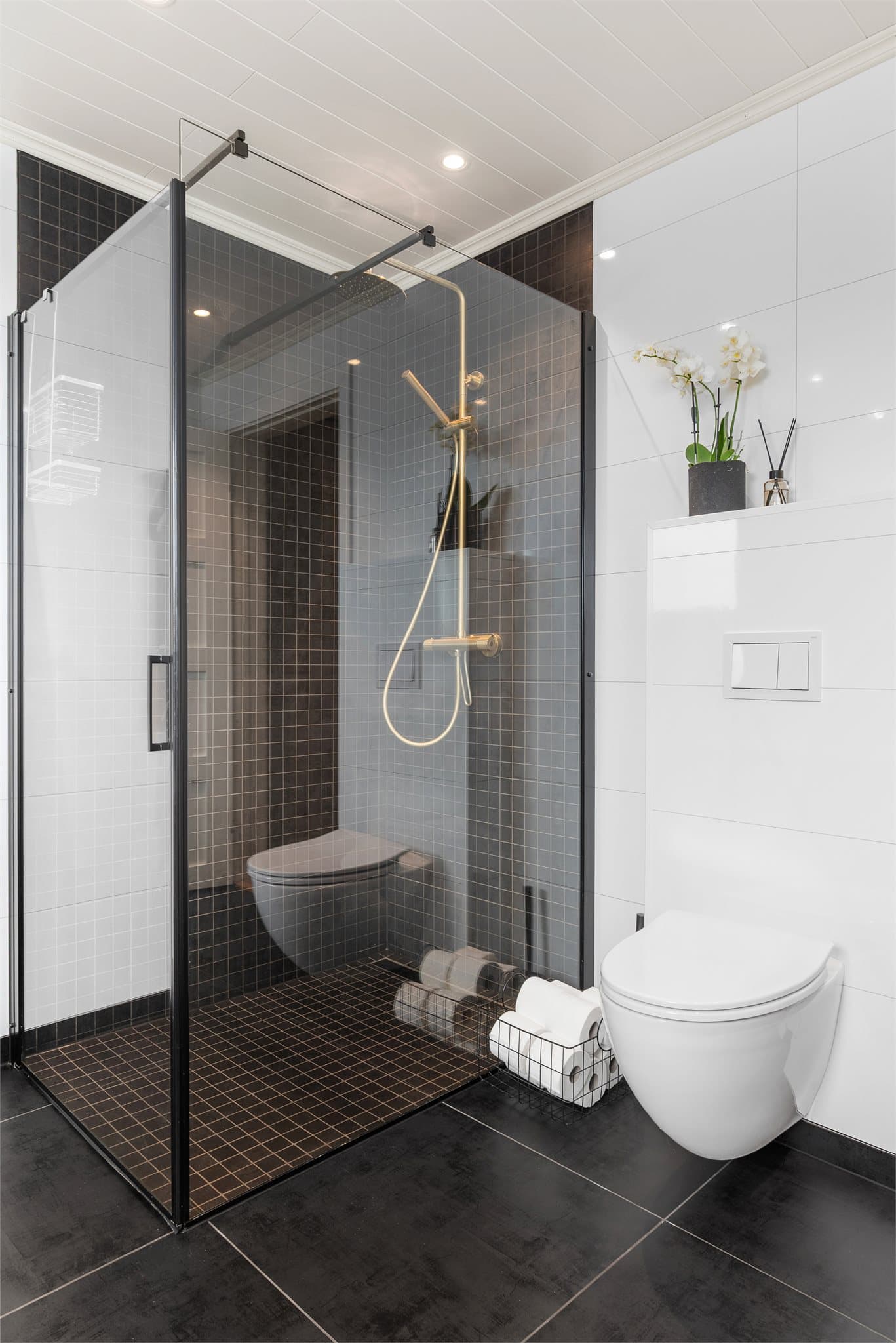 Badet er utstyrt med servant innredning, toalett, badekar og dusjhjørne.
