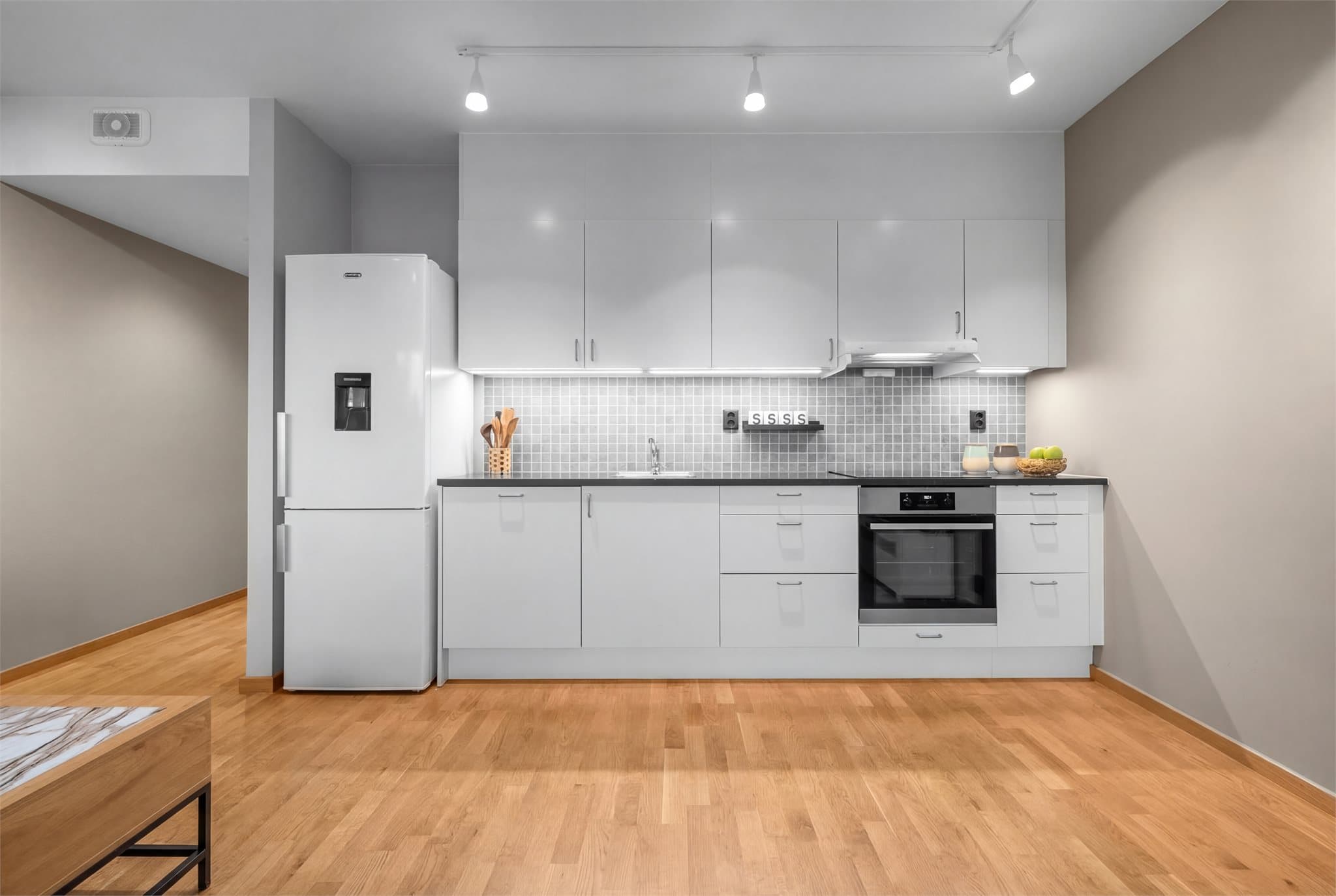 Kjøkkeninnredning med integrerte hvitevarer som stekeovn, platetopp og oppvaskmaskin.