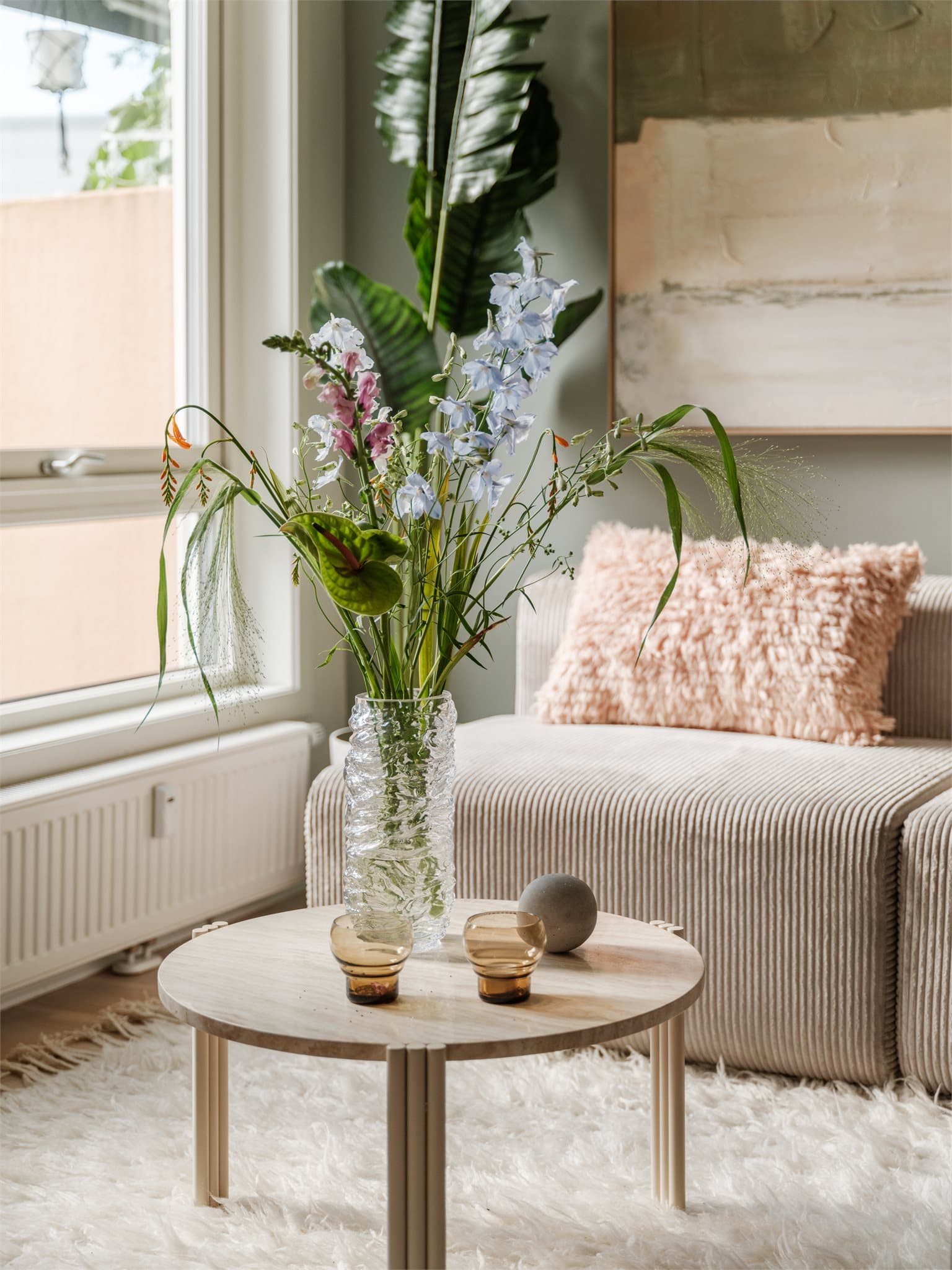 Lyset fra de store vinduene fremhever de fine overflatene i boligen.