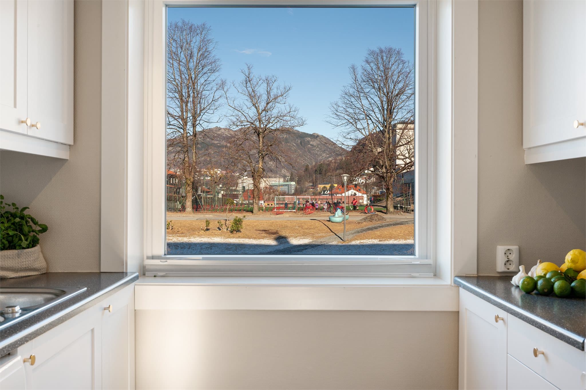 - Tidløs kjøkkeninnredning med hvite fronter og benkeplate i laminat. Merk stikkontakt over benkeplate -