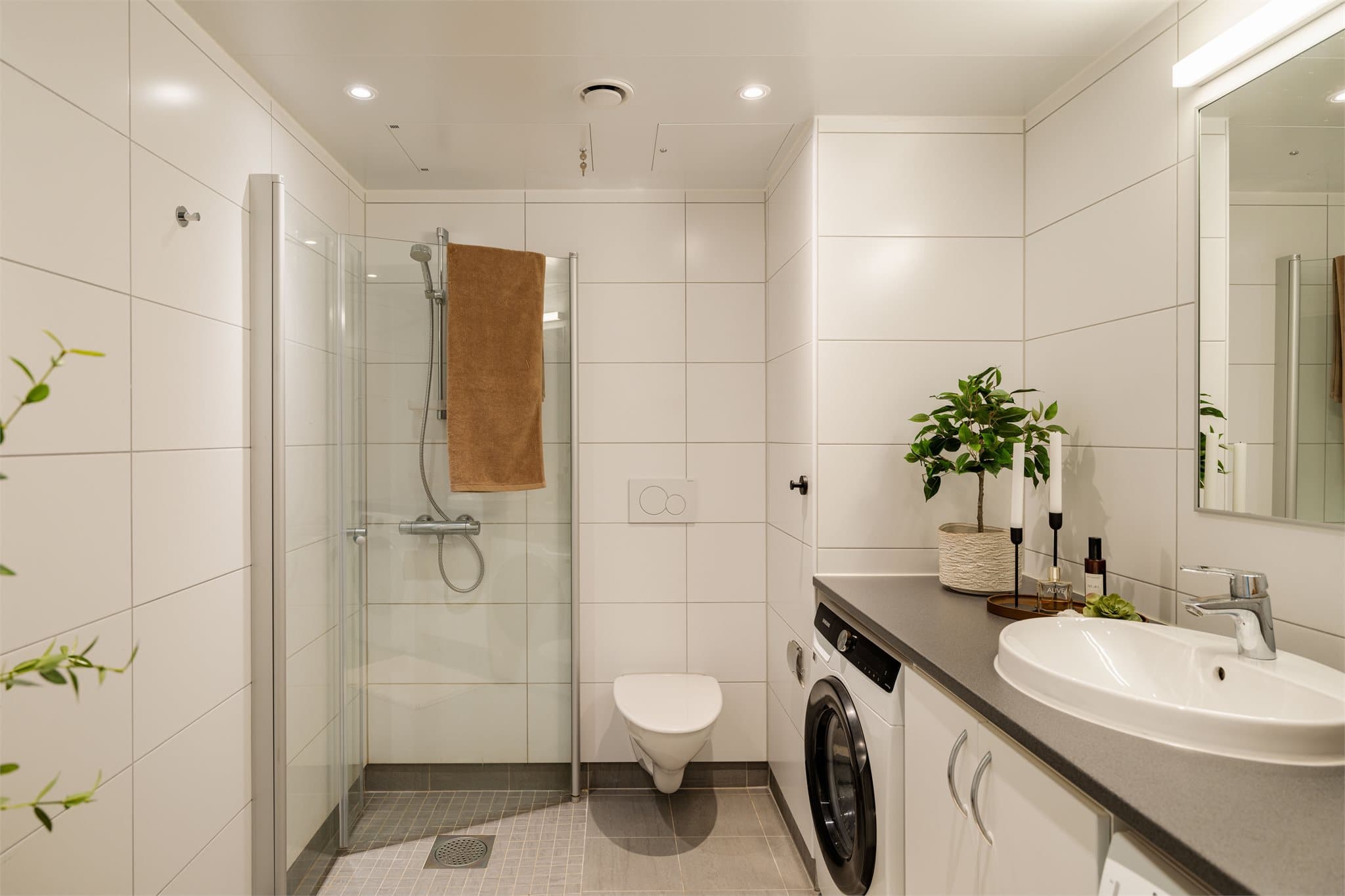 Badet er en prefabrikkert baderomskabin fra byggeåret, med varmekabler, dusjhjørne og vegghengt toalett.
