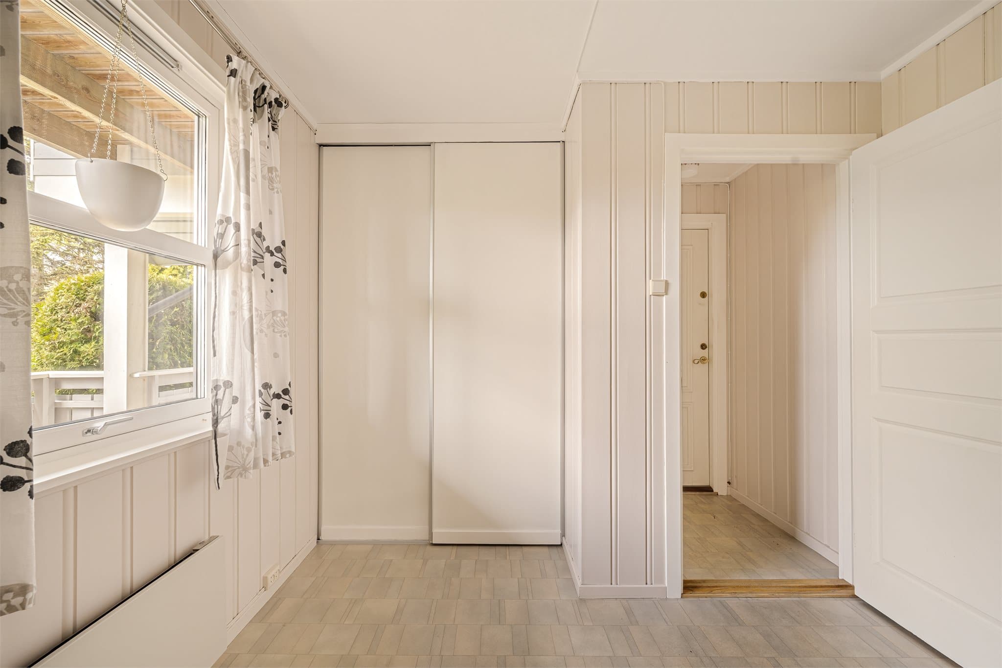 Fra inngangsparti 2 og kjøkken har man adkomst til et romslig areal med skyvedørsgarderobe. Vindfanget er registrert som matbod og rommet er registert som sykler/redskap og klær. Dette er endring fra tilleggsdel til hoveddel og vil være søknadspliktig.