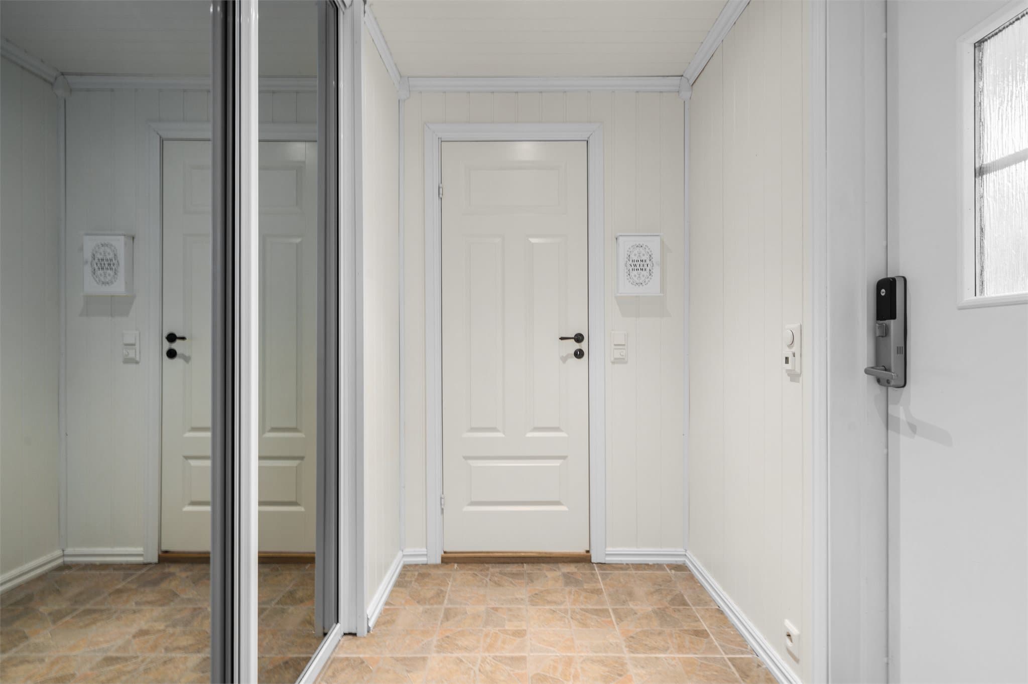 Velkommen inn! Lysmalt entré med skyvedørsgarderobe og adkomst til praktisk vaskerom.