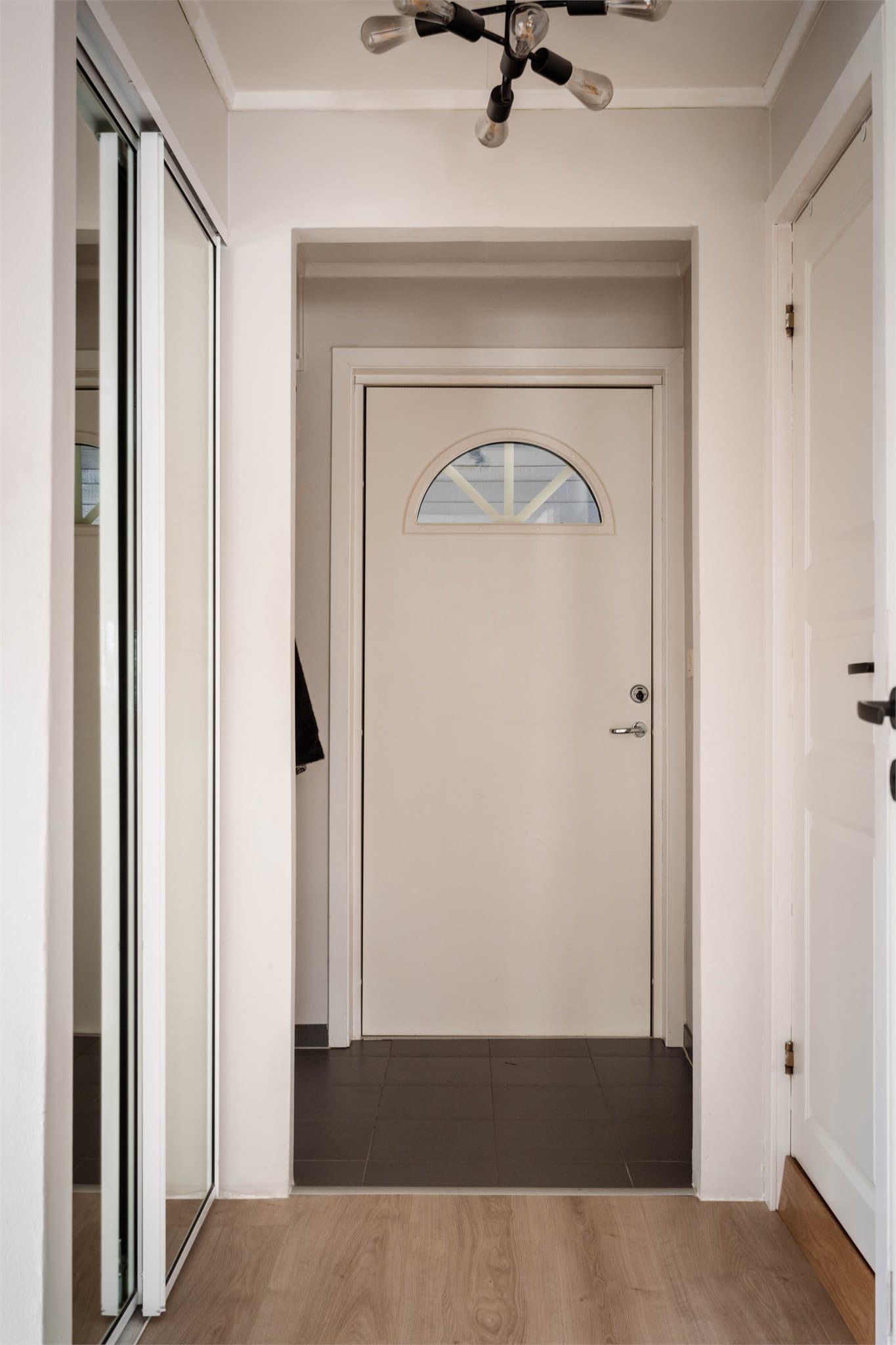 Entré med flislagt gulv og god plass til oppbevaring i skyvedørsgarderobe.