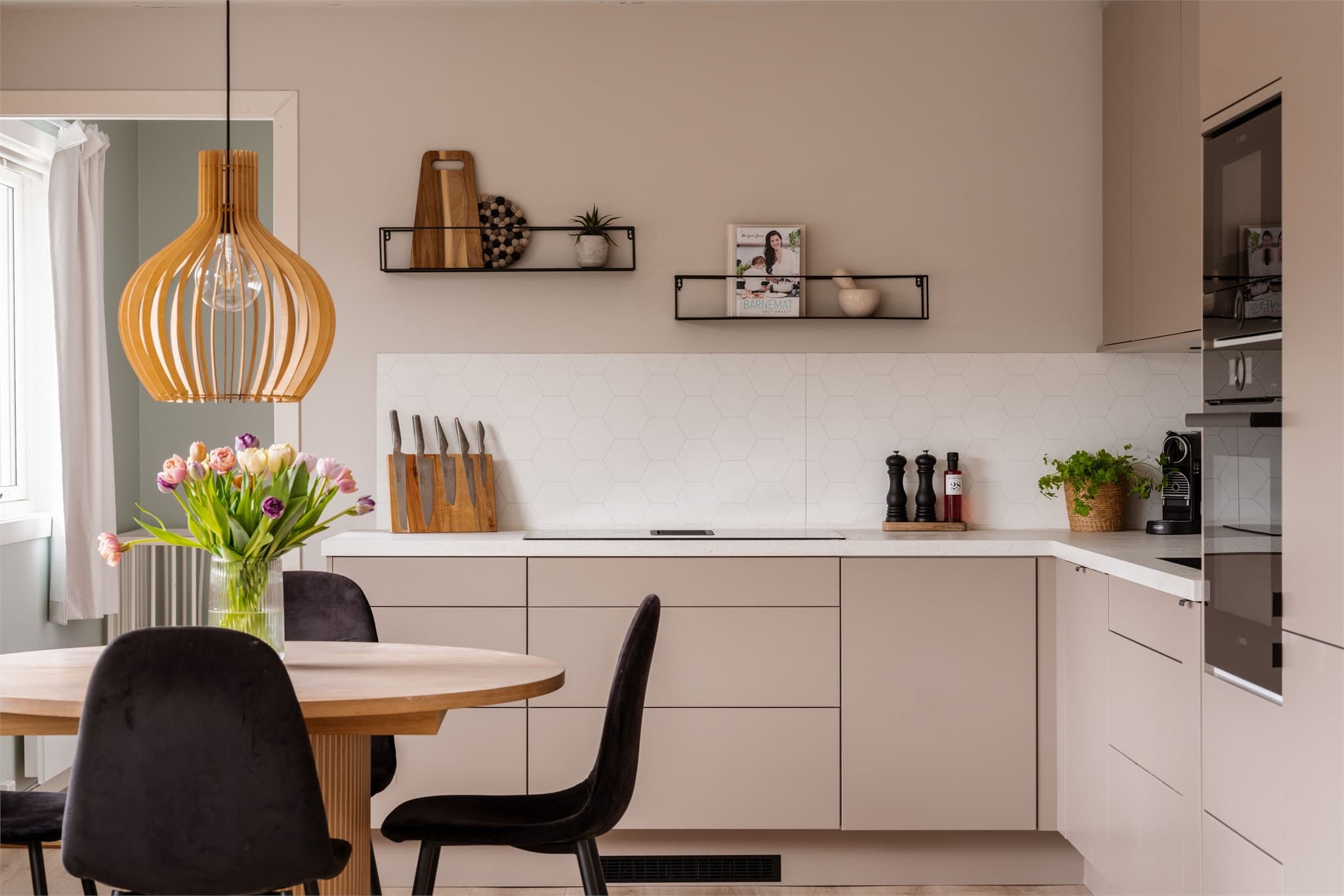 Innredningen har glatte, beige fronter og en slitesterk benkeplate i kompositt.