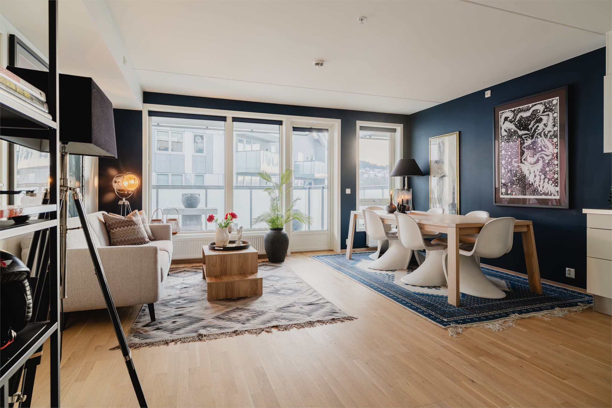 Den åpne løsningen mellom stue og kjøkken skaper en sosial og luftig atmosfære.