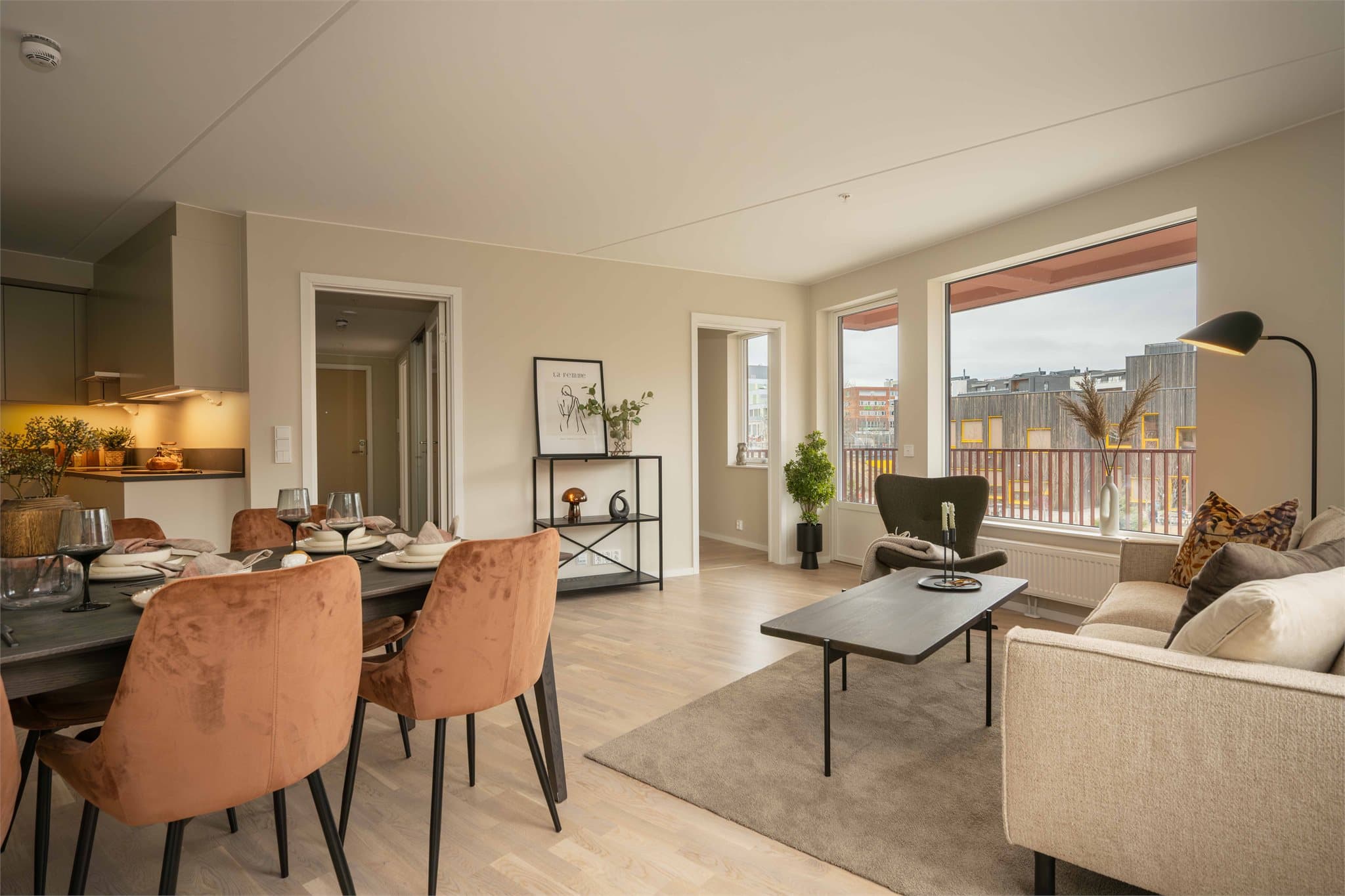 Den åpne løsningen mellom stue og kjøkken skaper en luftig og sosial atmosfære, med god plass til både sofagruppe og spisebord.