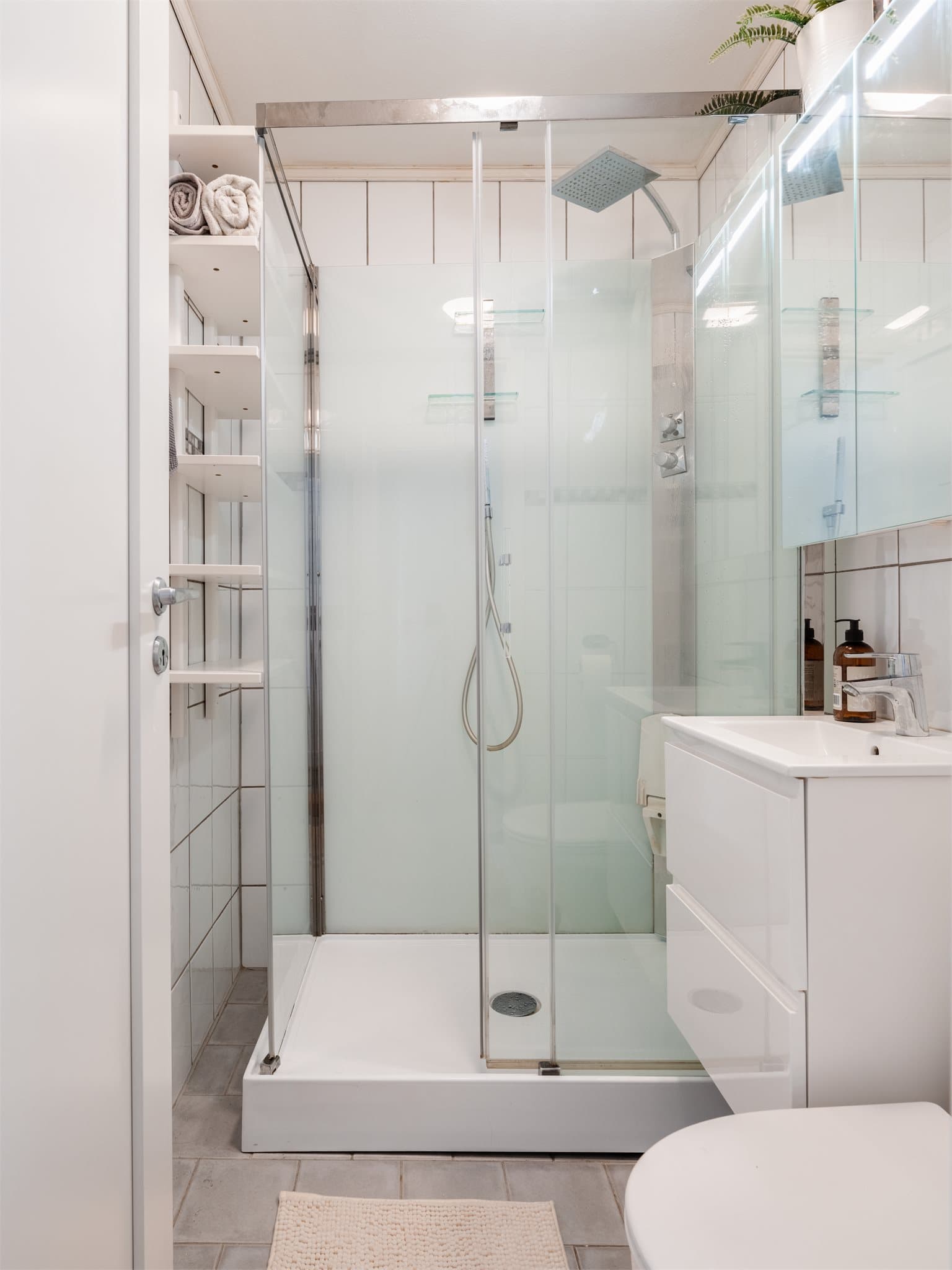 Badet er flislagt og ble i 2020 oppgradert med nytt dusjkabinett, servant med skap og speilskap.