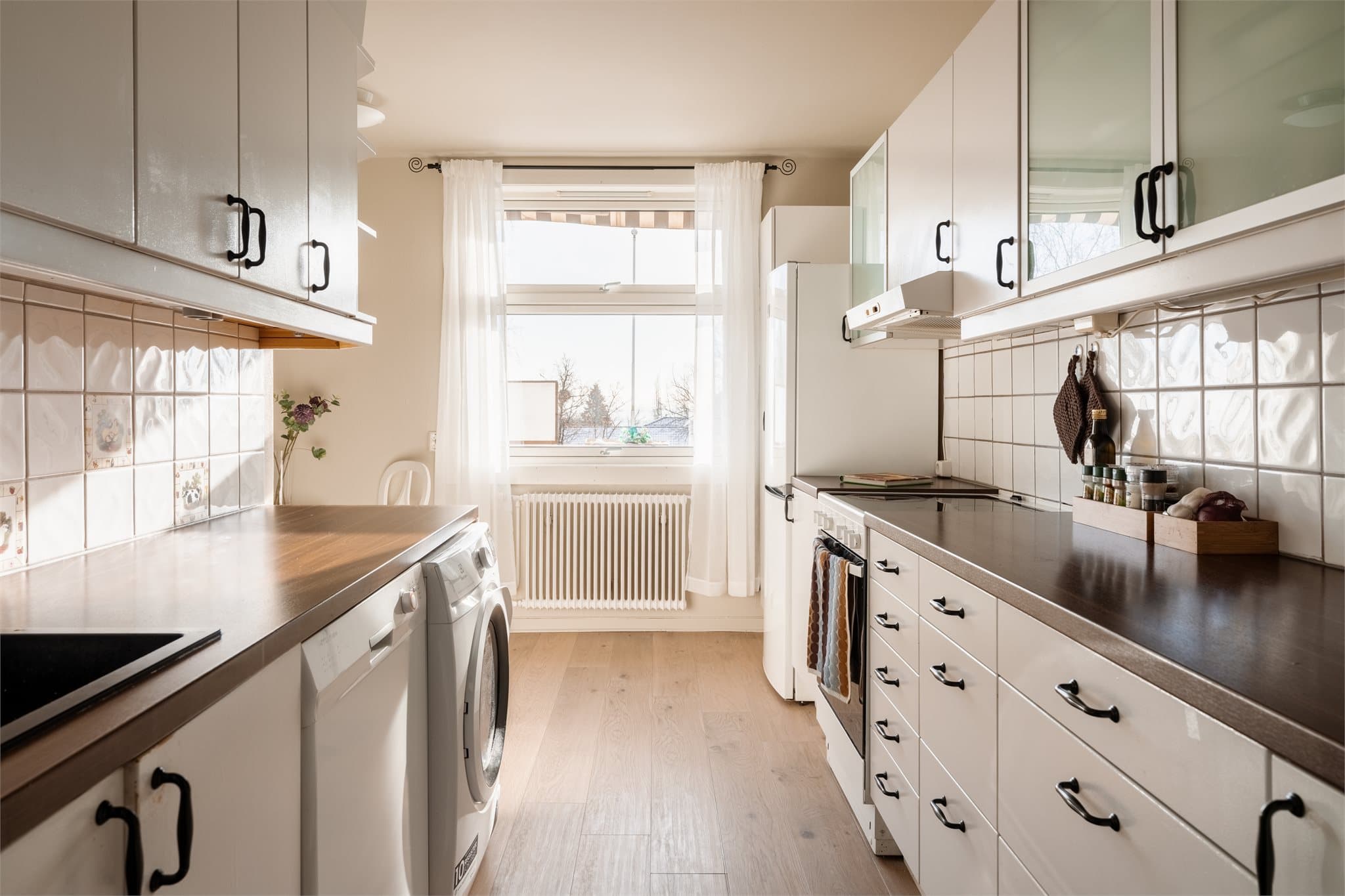 Praktisk kjøkken med innredning med glatte fronter og laminatbenkeplate.