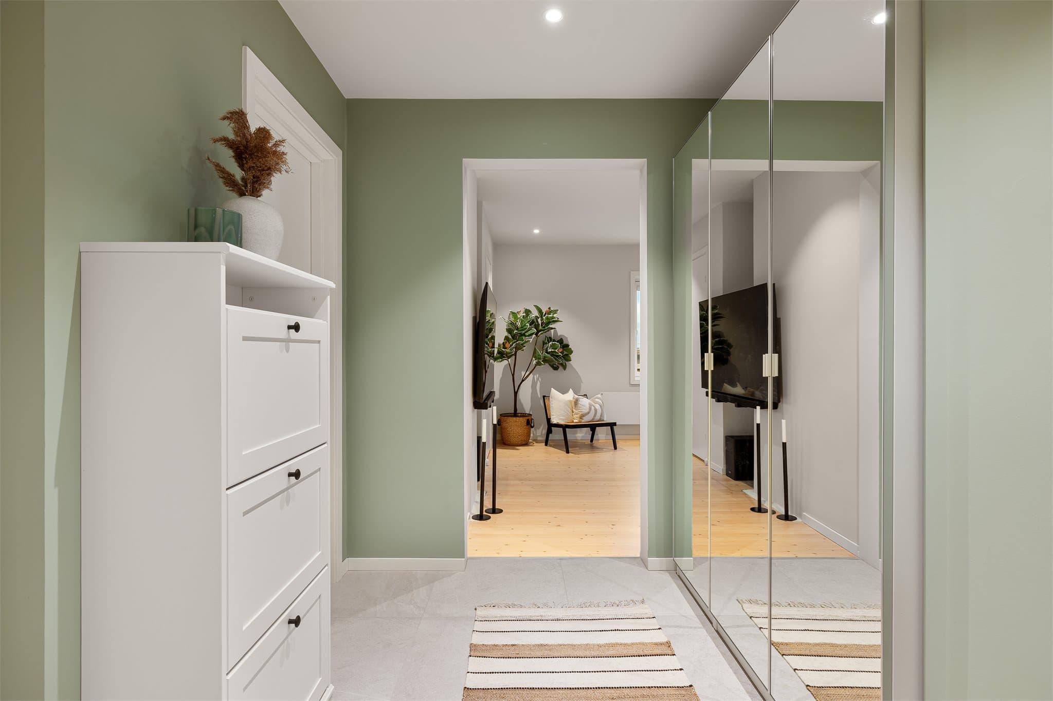 Innbydende gang med flislagt gulv, downlights i himlingen og gode oppbevaringsmuligheter.