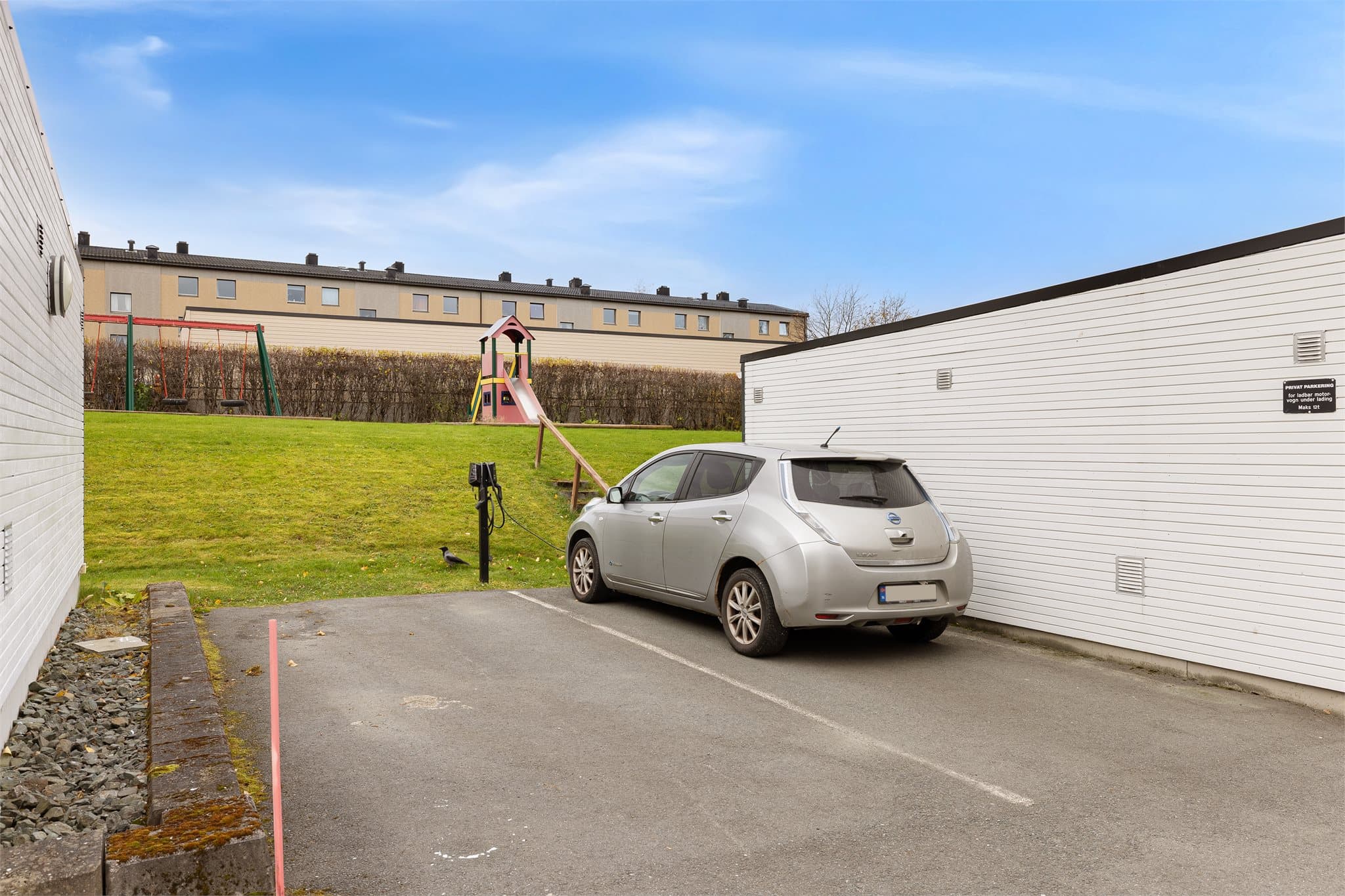 Parkeringsplasser utenfor blokkene, med lademulighet på parkeringsplassene mellom garasje 9 og 10.