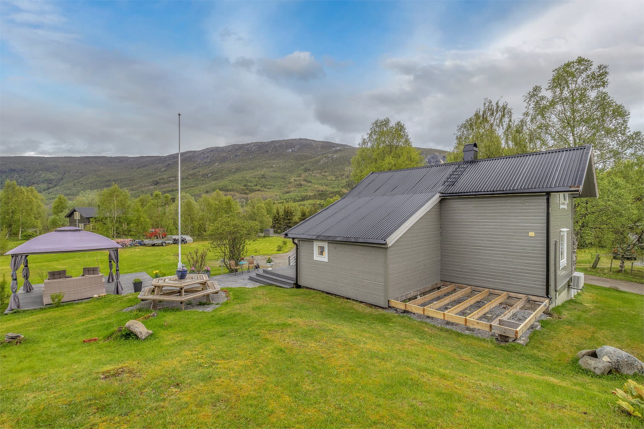 På baksiden og i front er det påbegynt ramverk med fundamentering på pilarer for tiltenkt tilbygg og veranda