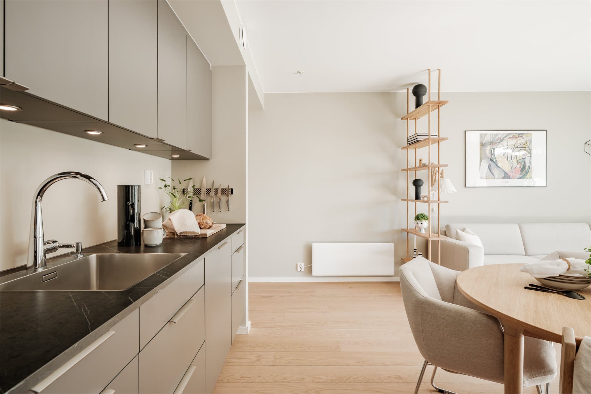 Kjøkkenet er utstyrt med hvitevarer i toppklasse og holder en gjennomført moderne og stilren standard, med generøse skap- og arbeidsflater.