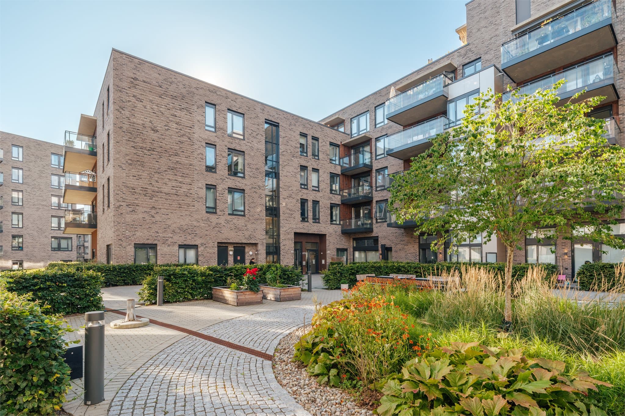 Flotte fellesområder med frodige planter og gangstier.