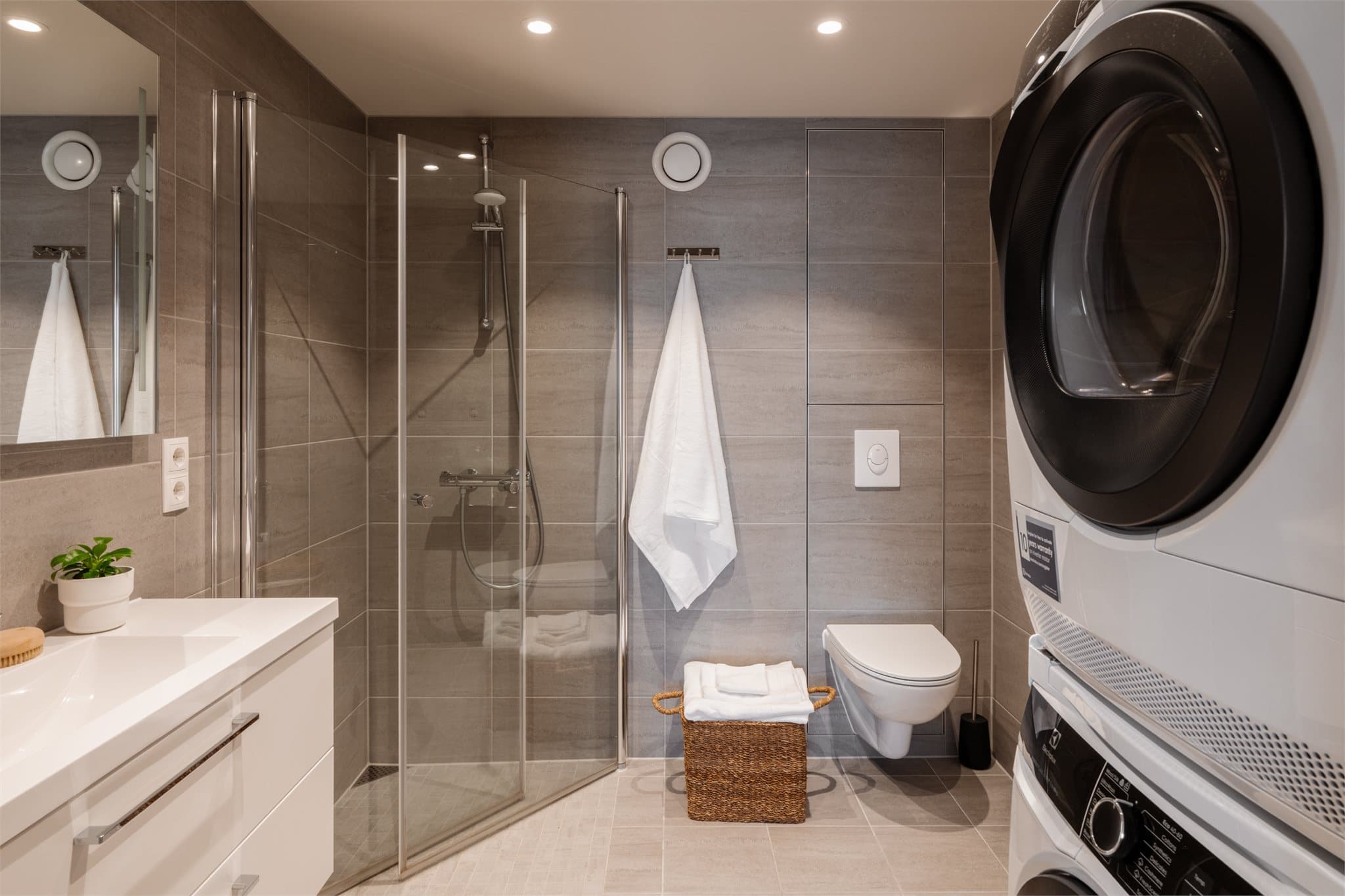 Bad med innfellbare dører, komplettert med integrert takbelysning som skaper et lyst og innbydende rom.