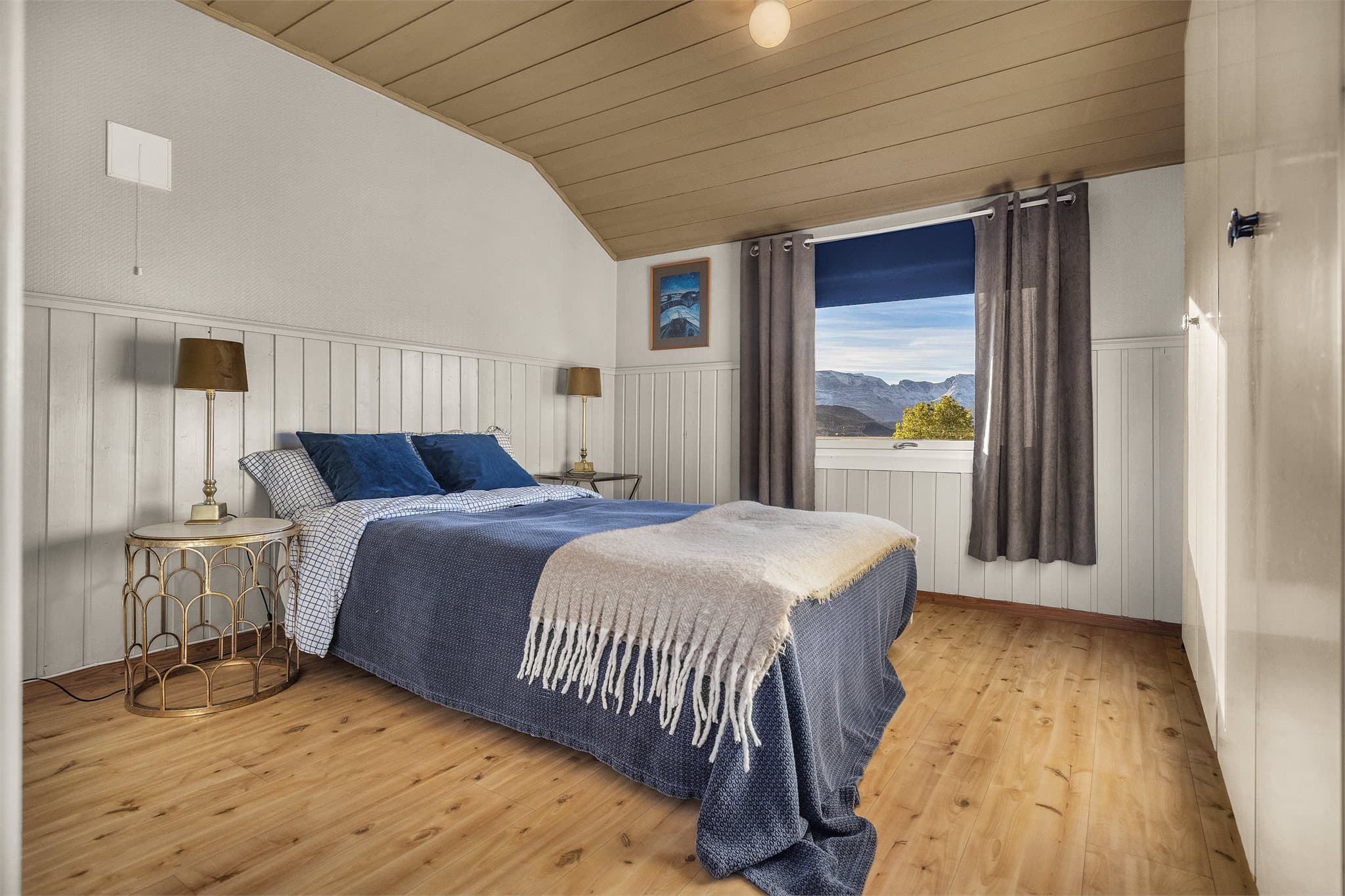 Soverom med god plass til dobbeltseng og utsikt mot fjord og fjell.