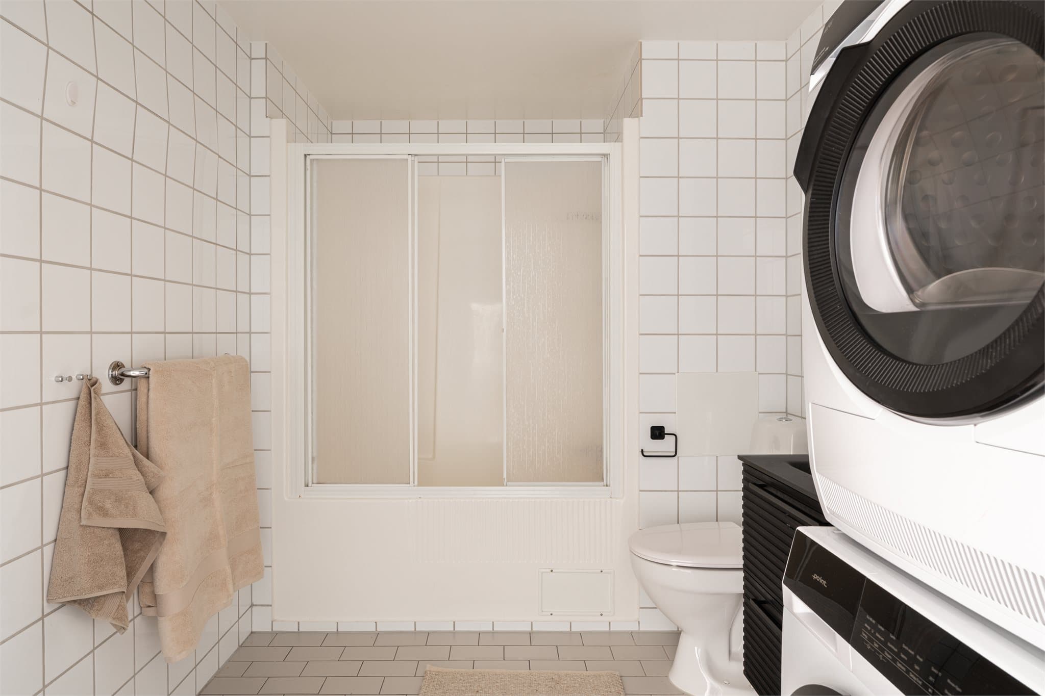 Badet har flislagte gulv og vegger fra byggeåret. Badet har ikke sluk, men direkte avløp fra bunnen av dusjkabinettet. Servantskap og toalett er fra 2023/24.