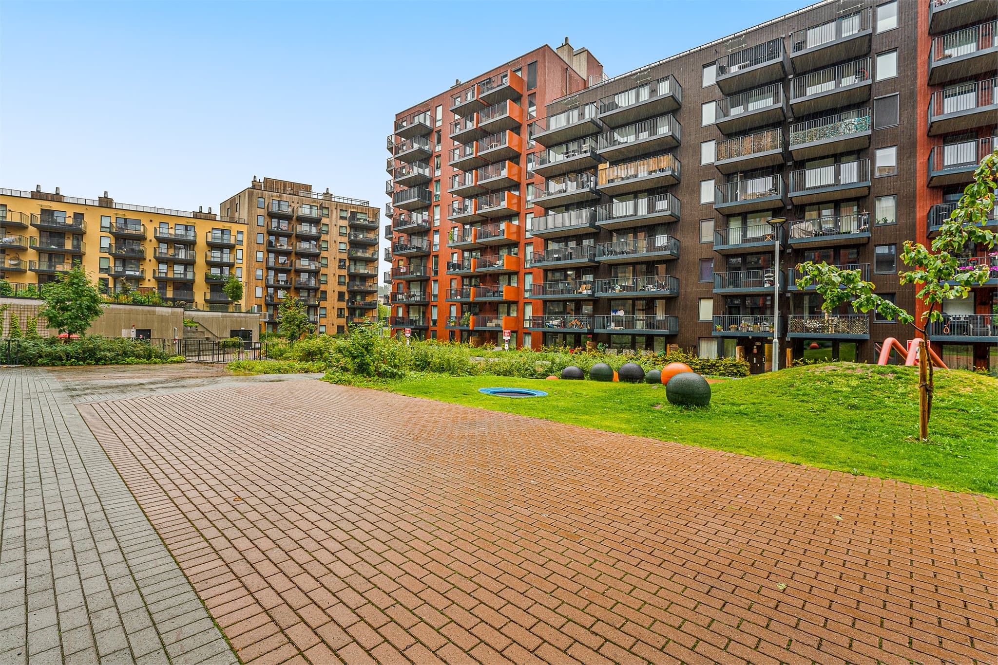 Frodig beplantning og åpne fellesarealer mellom boligblokkene i Lørenskog Hageby.