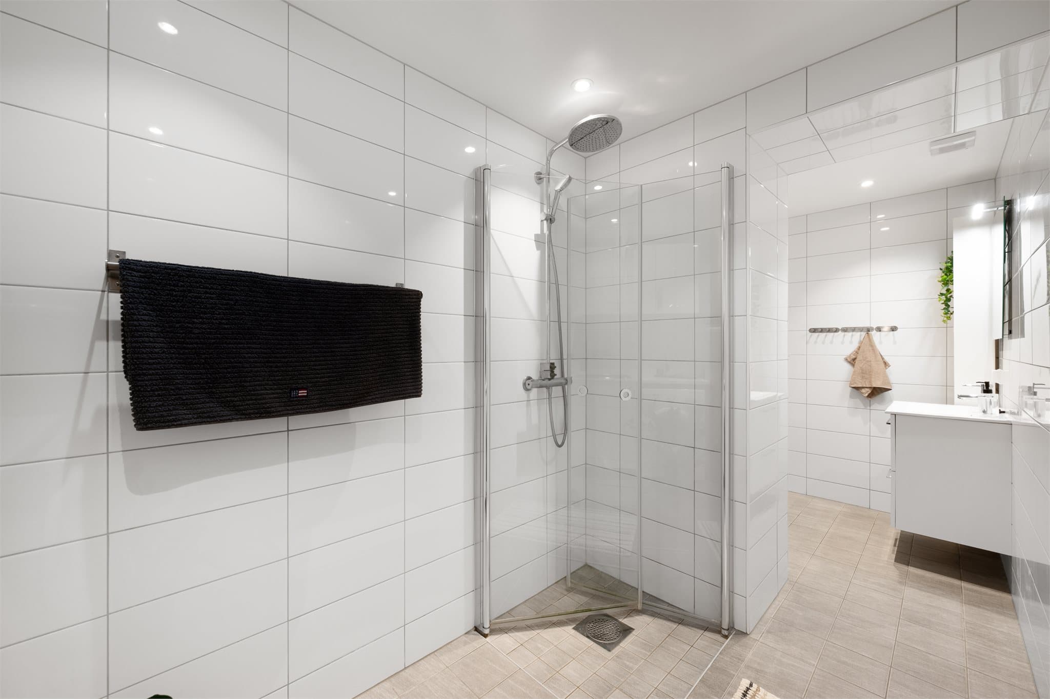 - Badet er flislagt med gulvvarme og har dusjhjørne med innfellbare glassdører -