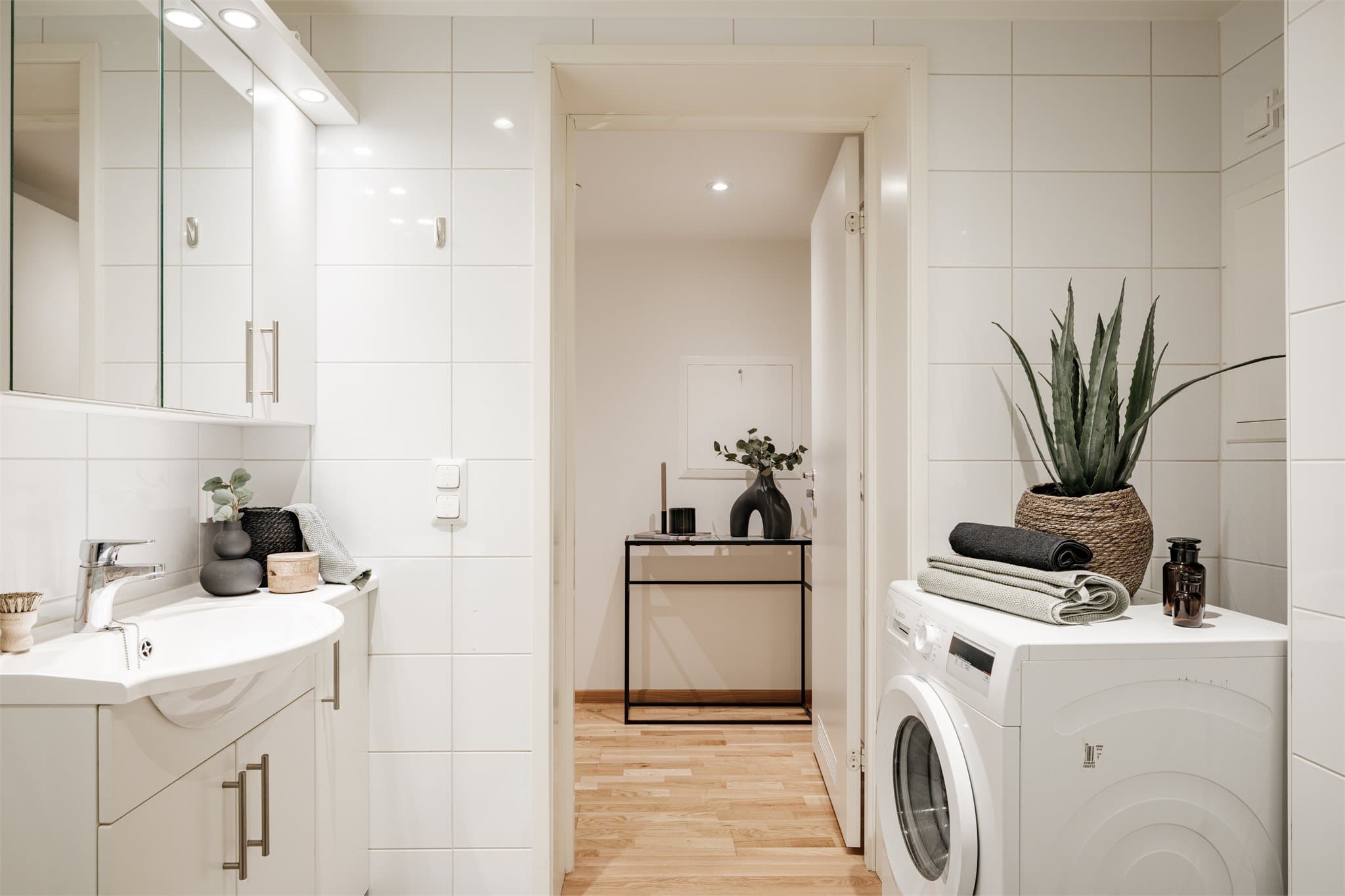 Rommet er utstyrt med innredning bestående av nedfelt servant med underskap og 1-greps blandebatteri, speilskap med lys, dusjhjørne med glassdører, vegghengt toalett, teknisk skap for vannrør og opplegg for vaskemaskin.