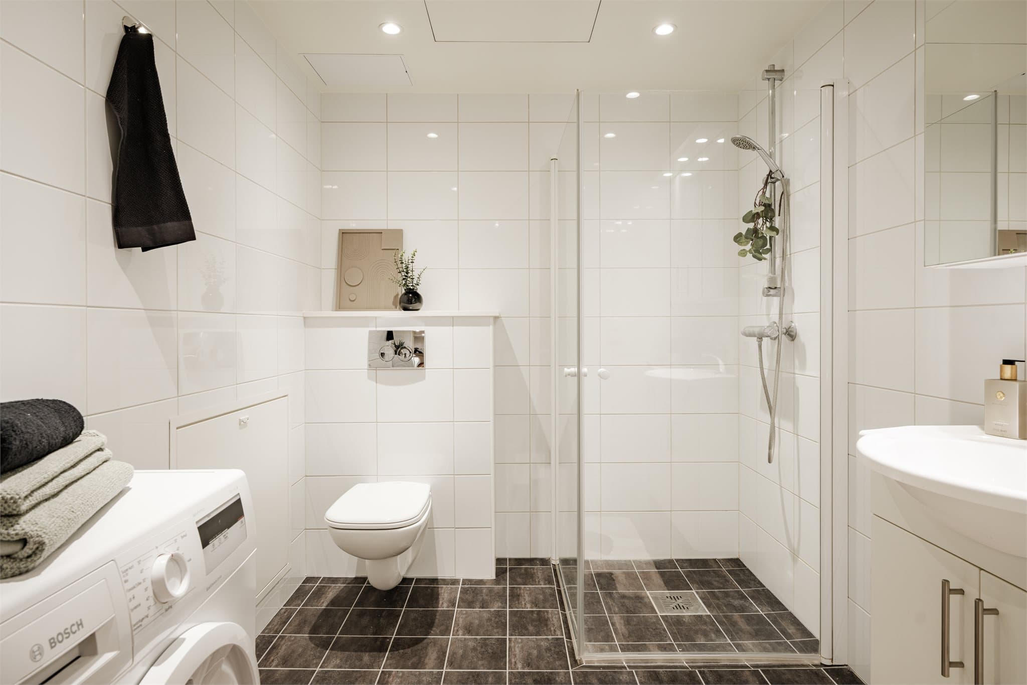 Flislagt baderom med malt slett himling.