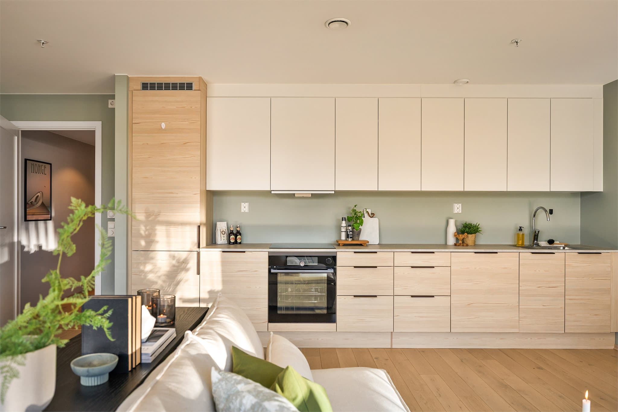 Kjøkkeninnredningen har slette fronter med laminat benkeplate.