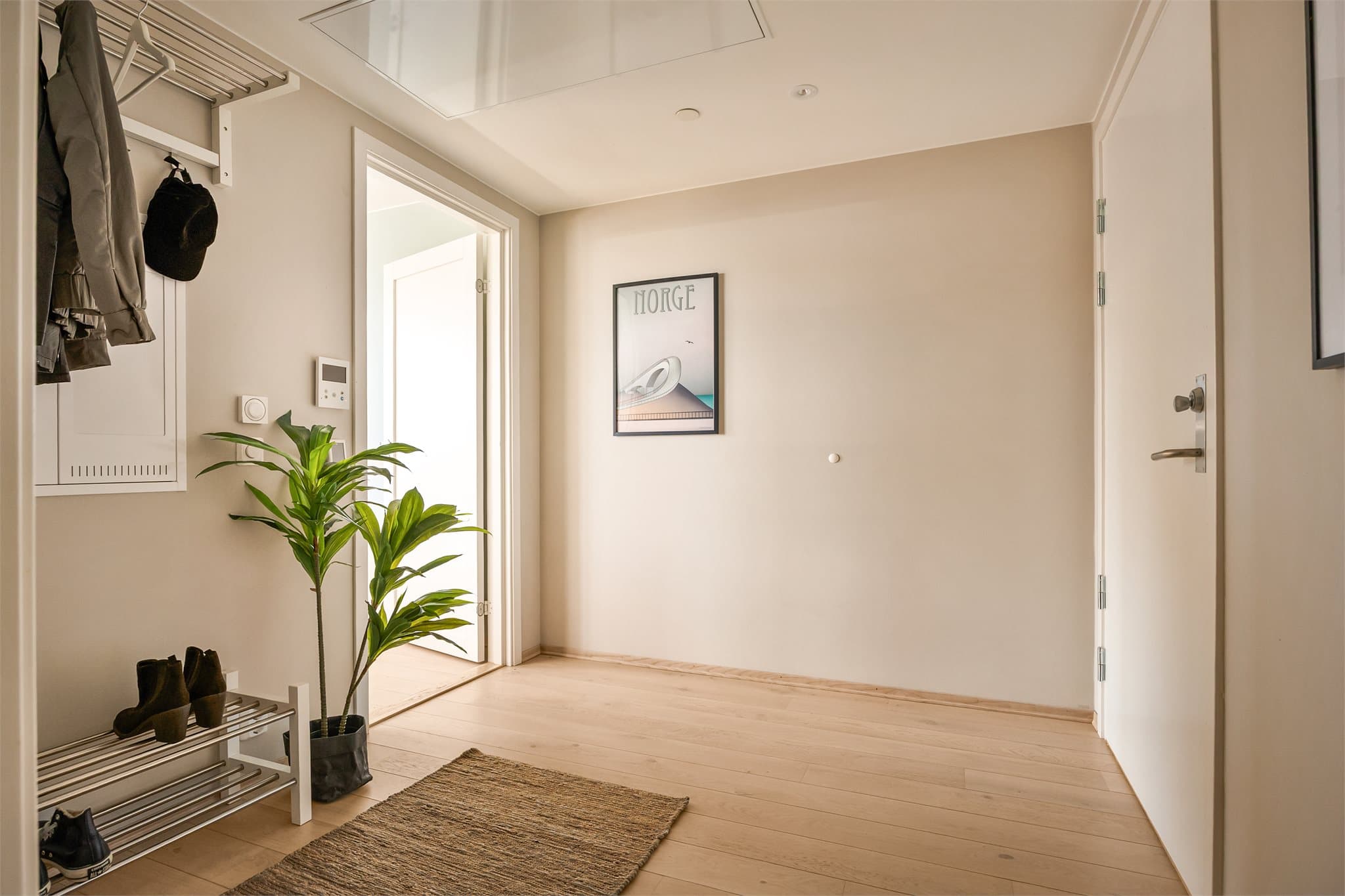 Lys og innbydende entré med knaggoppheng og downlights i himling.