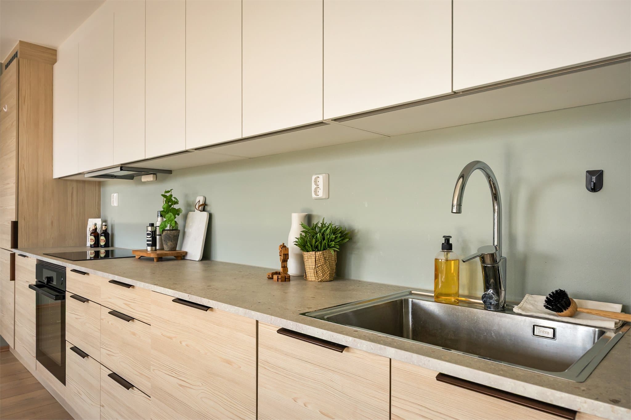 Innredningen har nedfelt oppvaskum og integrerte hvitevarer som medfølger handelen.