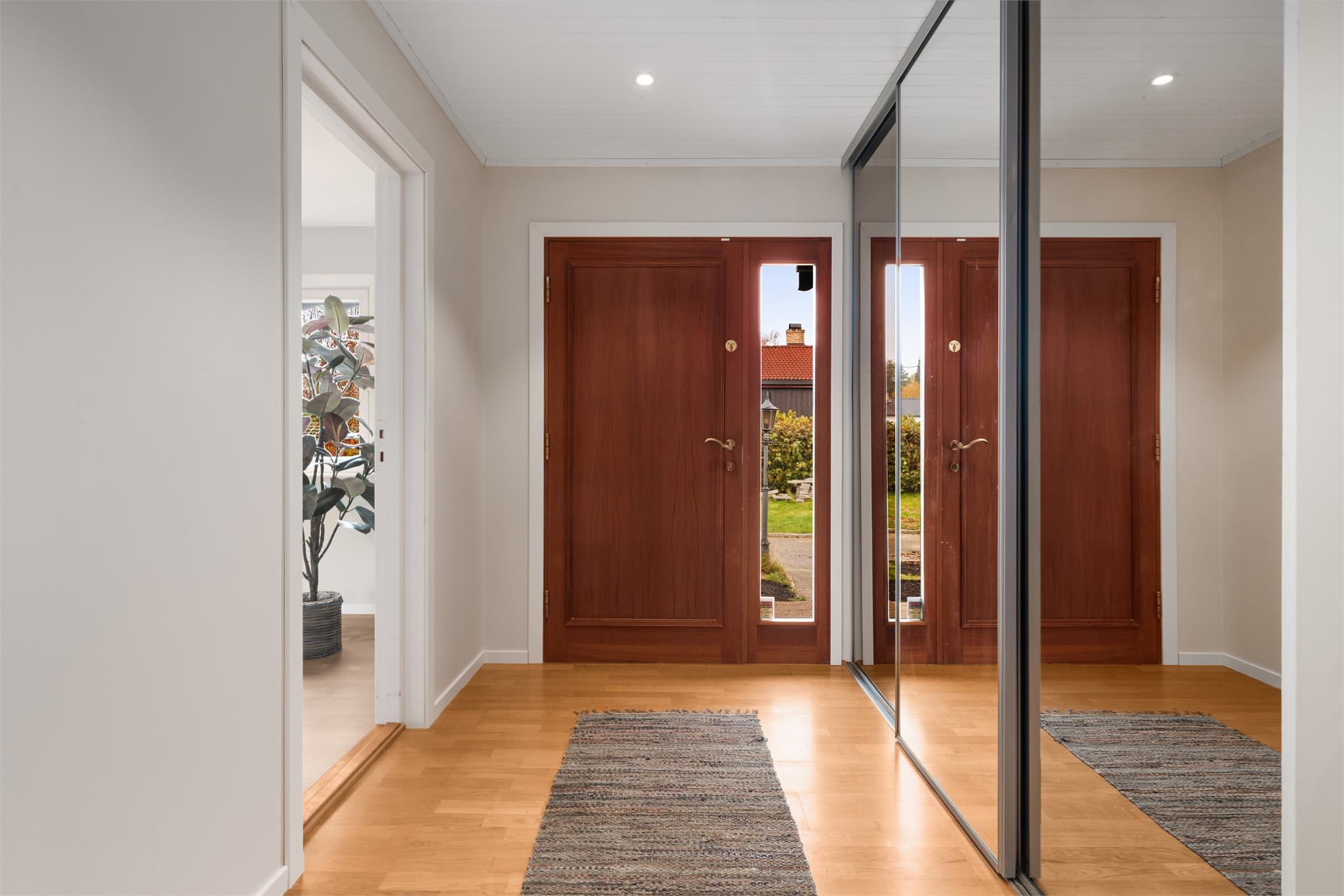 Entréen er innredet med skyvedørsgarderobe med speilfronter.